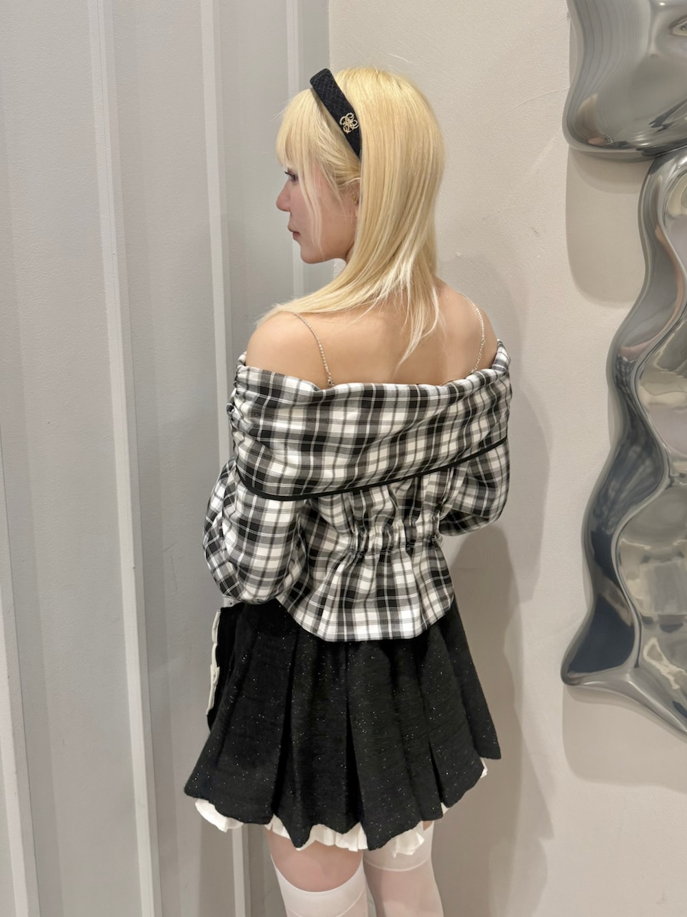 ホワイト系のシャツ/ブラウス、ブラック系のスカート、ブラック系のパンプスを着用したレディースの春コーディネートの6枚目の写真