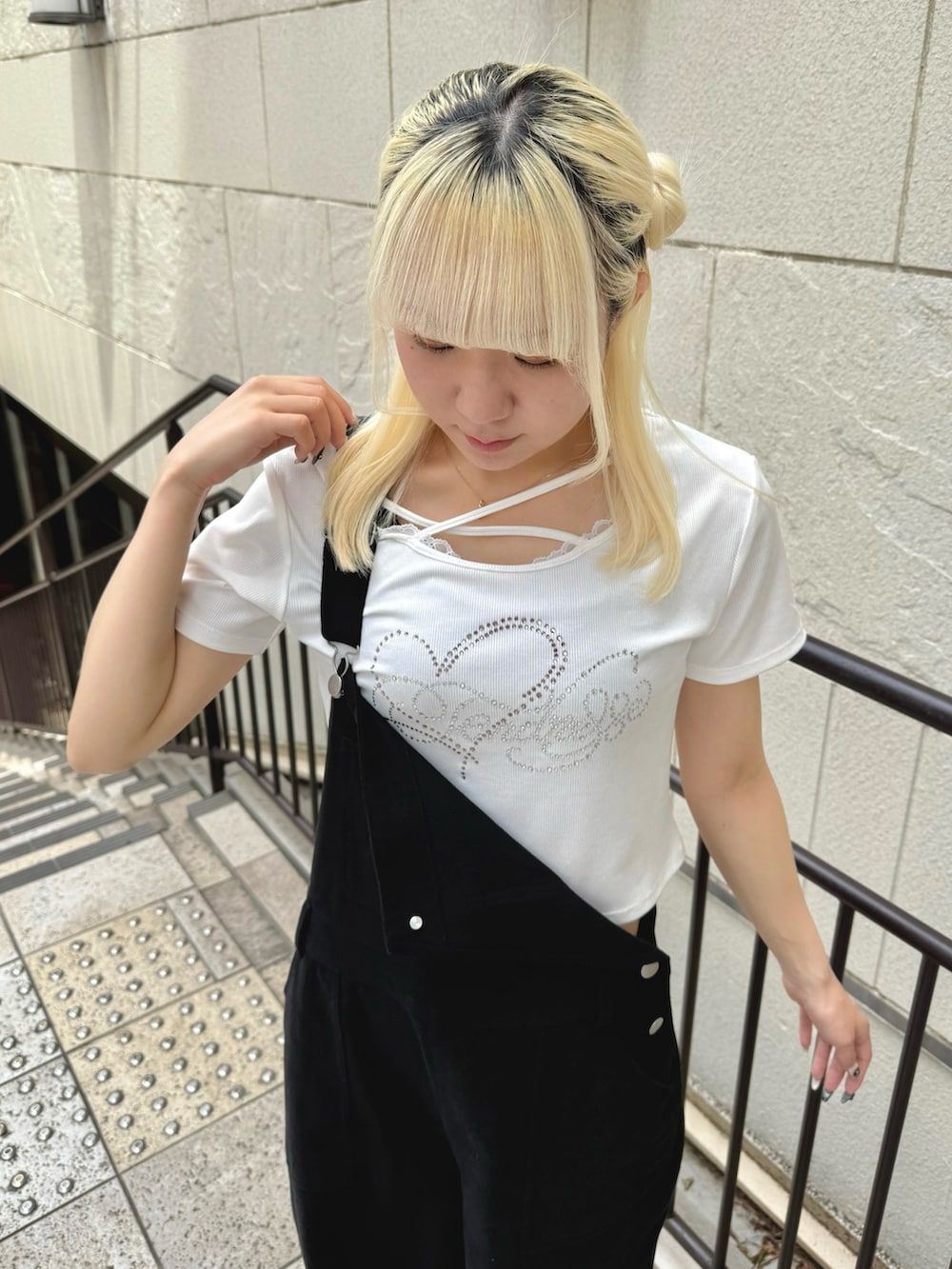 ブラック系のサロペット/オーバーオール、ホワイト系のTシャツ/カットソー、ホワイト系のサンダルを着用したレディースの夏コーディネートの6枚目の写真