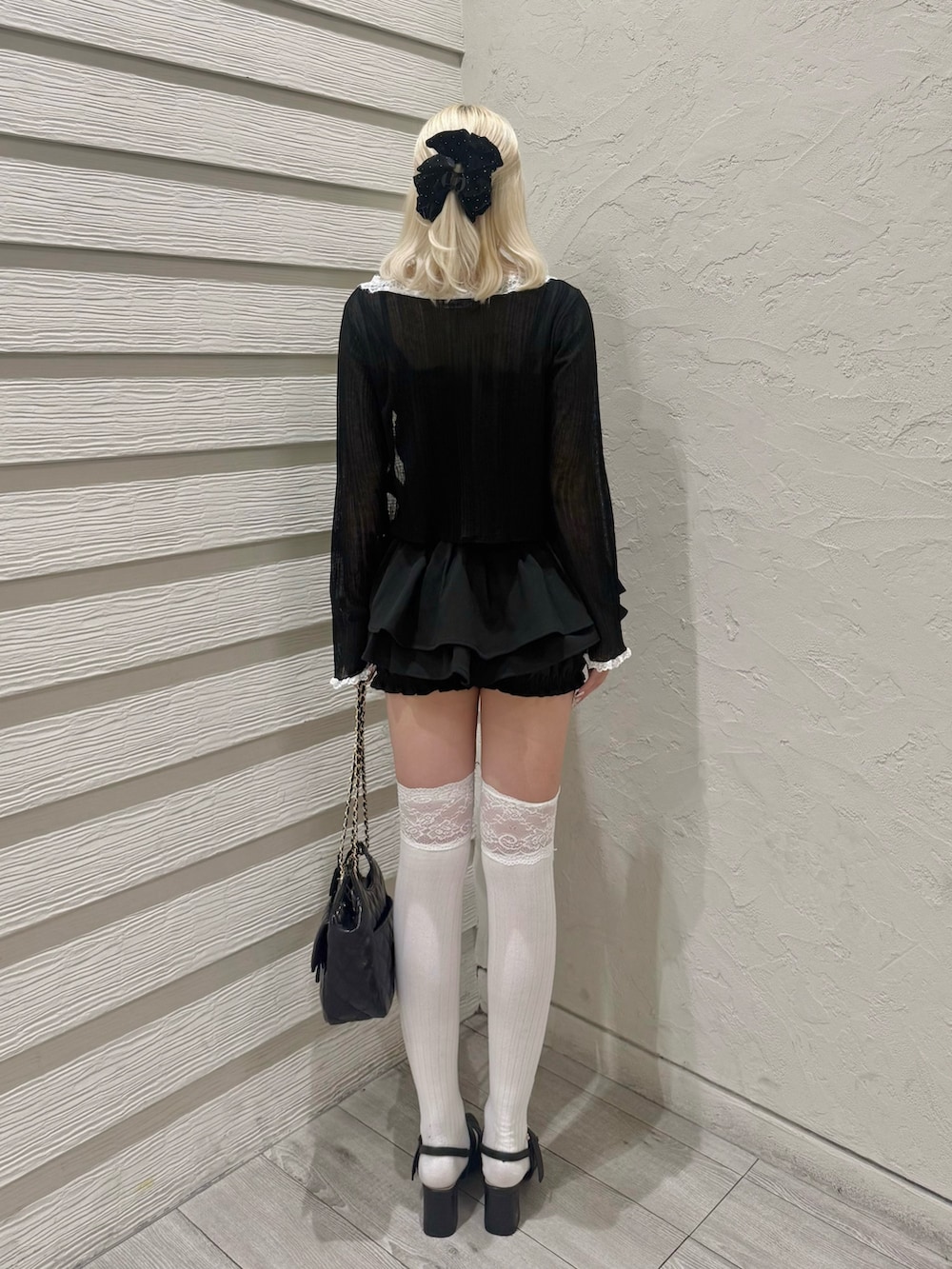 ブラック系のカーディガン/ボレロ、ブラック系のニット/セーター、ブラック系のショルダーバッグを着用したレディースの春コーディネートの3枚目の写真