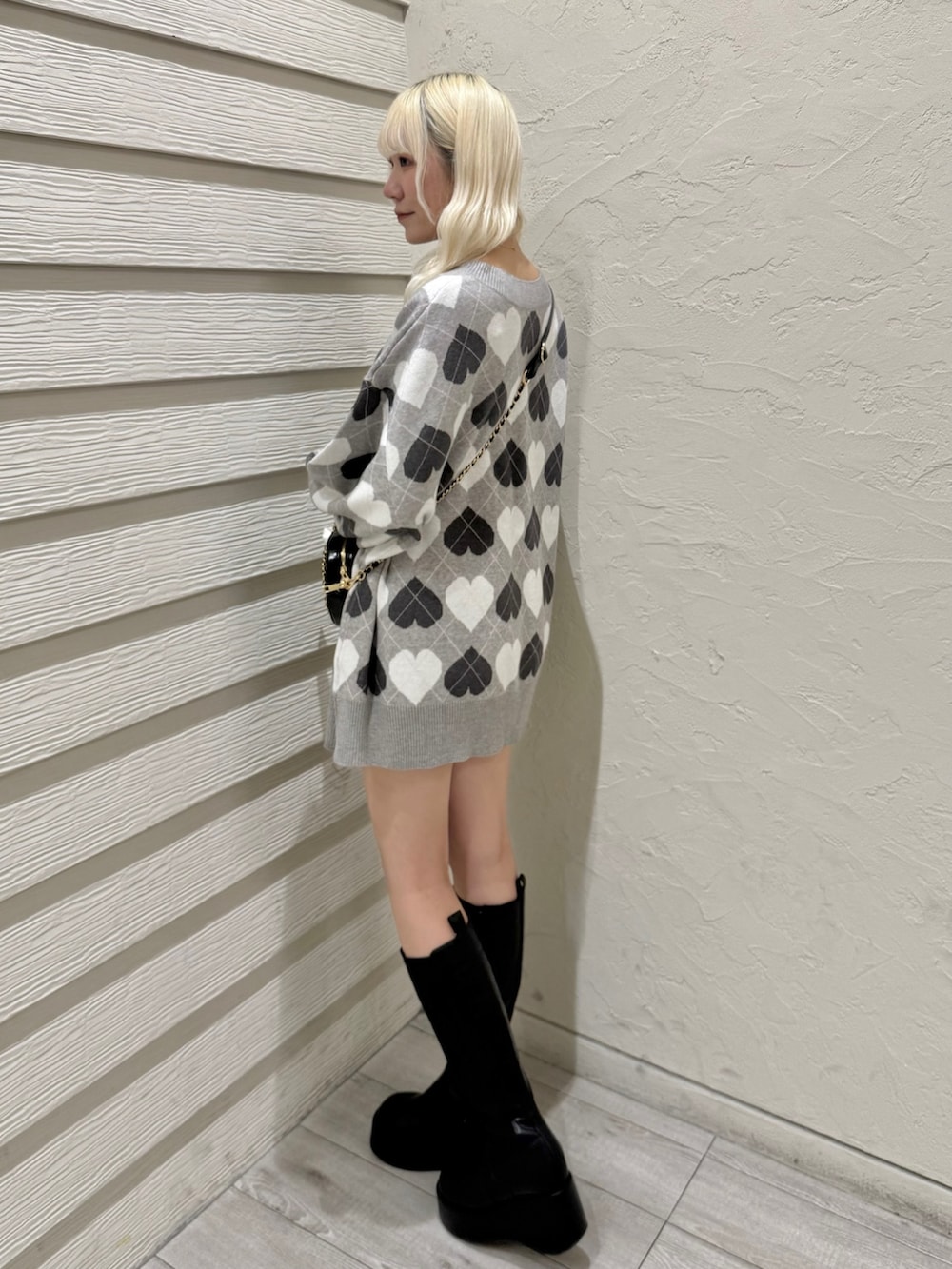 ブラック系のショルダーバッグ、グレー系のワンピース、ブラック系のブーツを着用したレディースの冬コーディネートの2枚目の写真