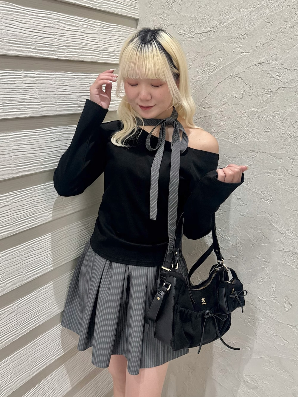 ブラック系のショルダーバッグ、グレー系のスカート、ブラック系のTシャツ/カットソーを着用したレディースの冬コーディネートの4枚目の写真