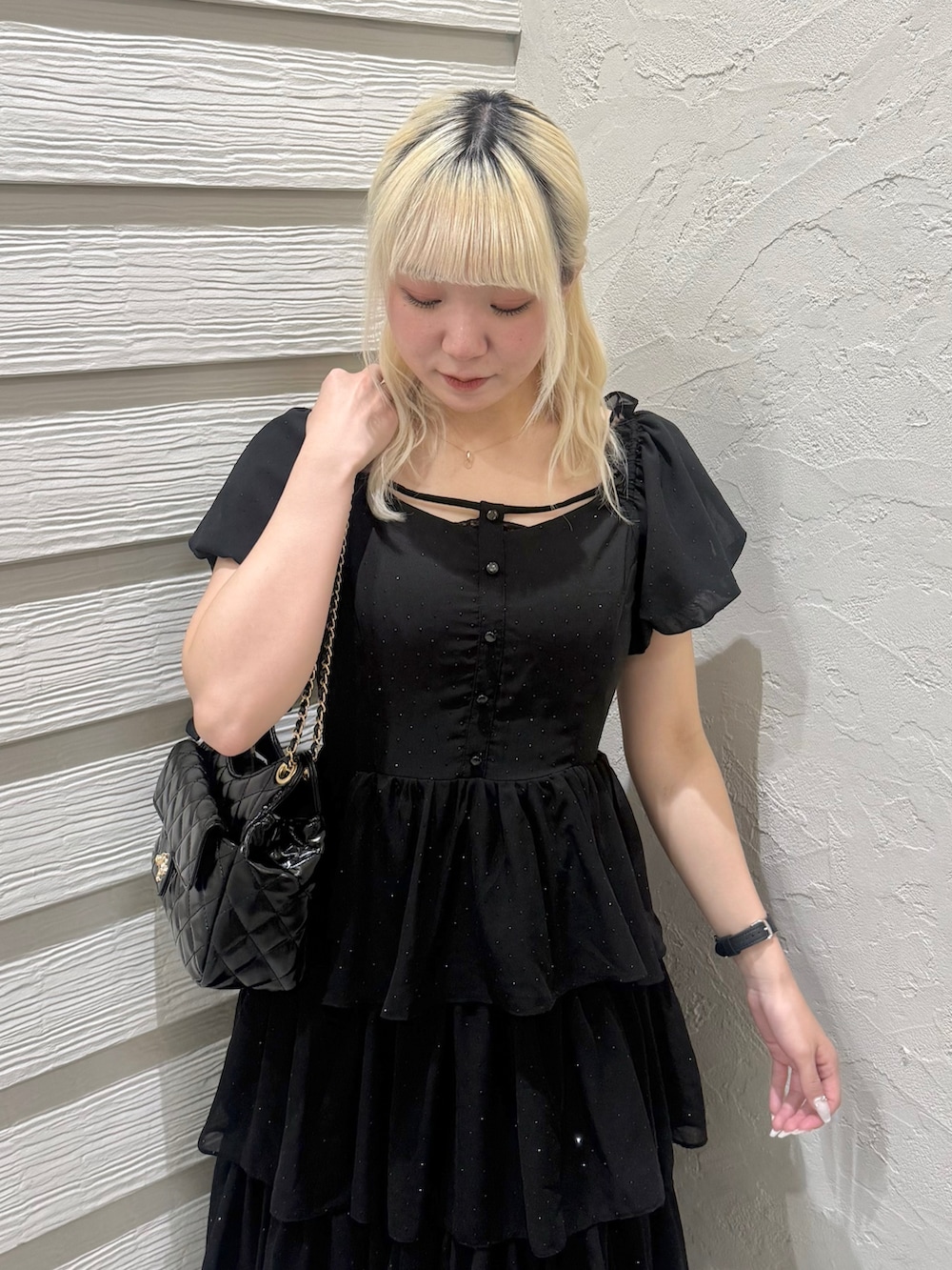 ブラック系のワンピース、ブラック系のショルダーバッグ、ブラック系のパンプスを着用したレディースの春コーディネートの5枚目の写真