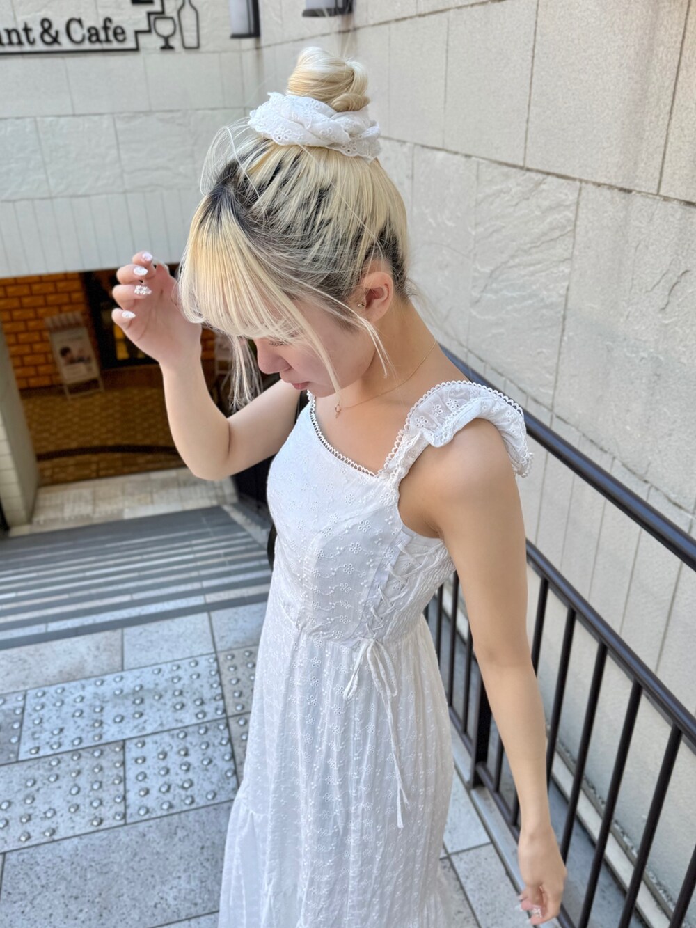 ブルー系のデニムジャケット、ブラック系のショルダーバッグ、ホワイト系のワンピースを着用したレディースの春コーディネートの6枚目の写真