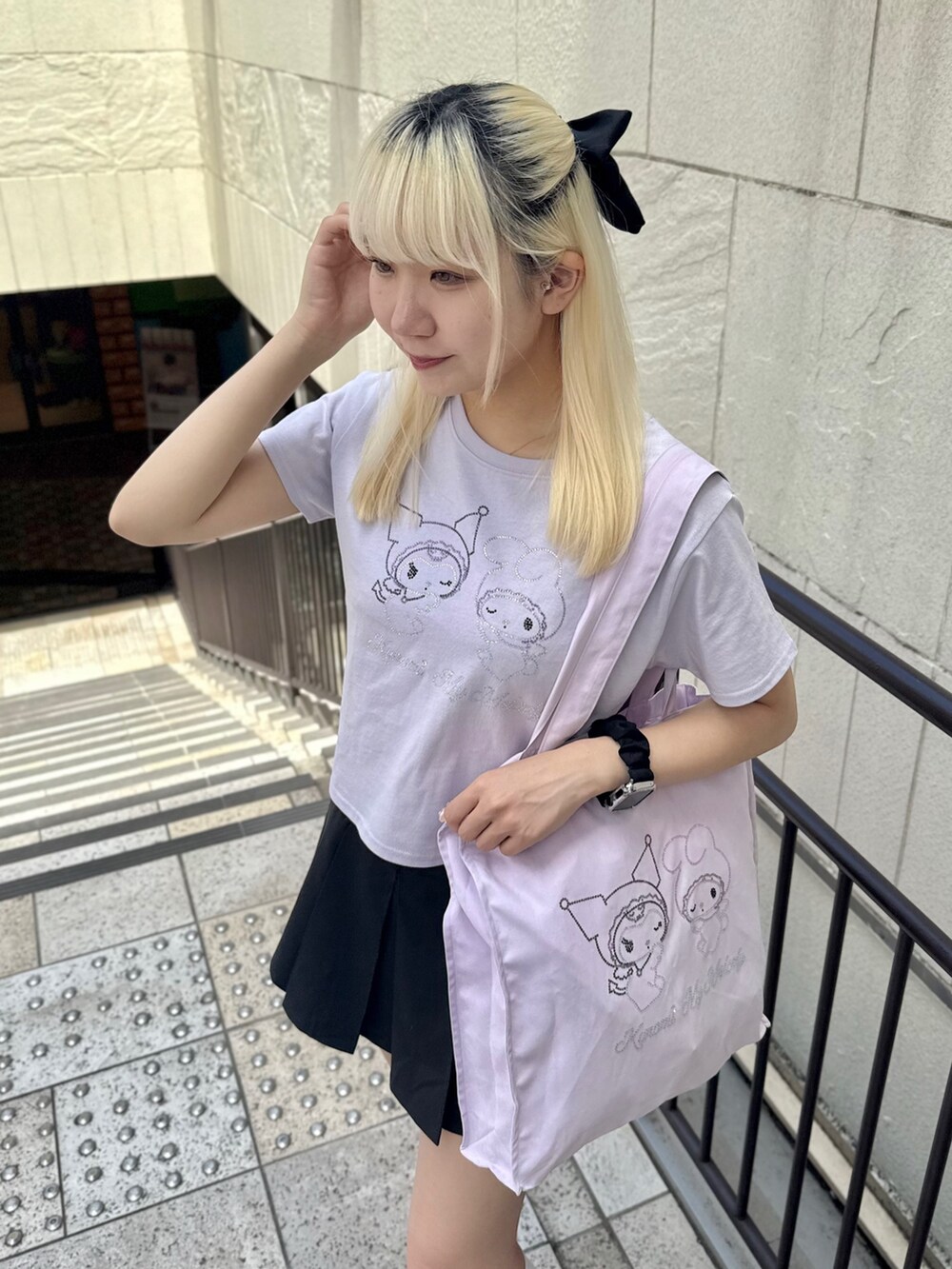 パープル系のトートバッグ、パープル系のTシャツ/カットソー、ブラック系のスカートを着用したレディースの夏コーディネートの5枚目の写真