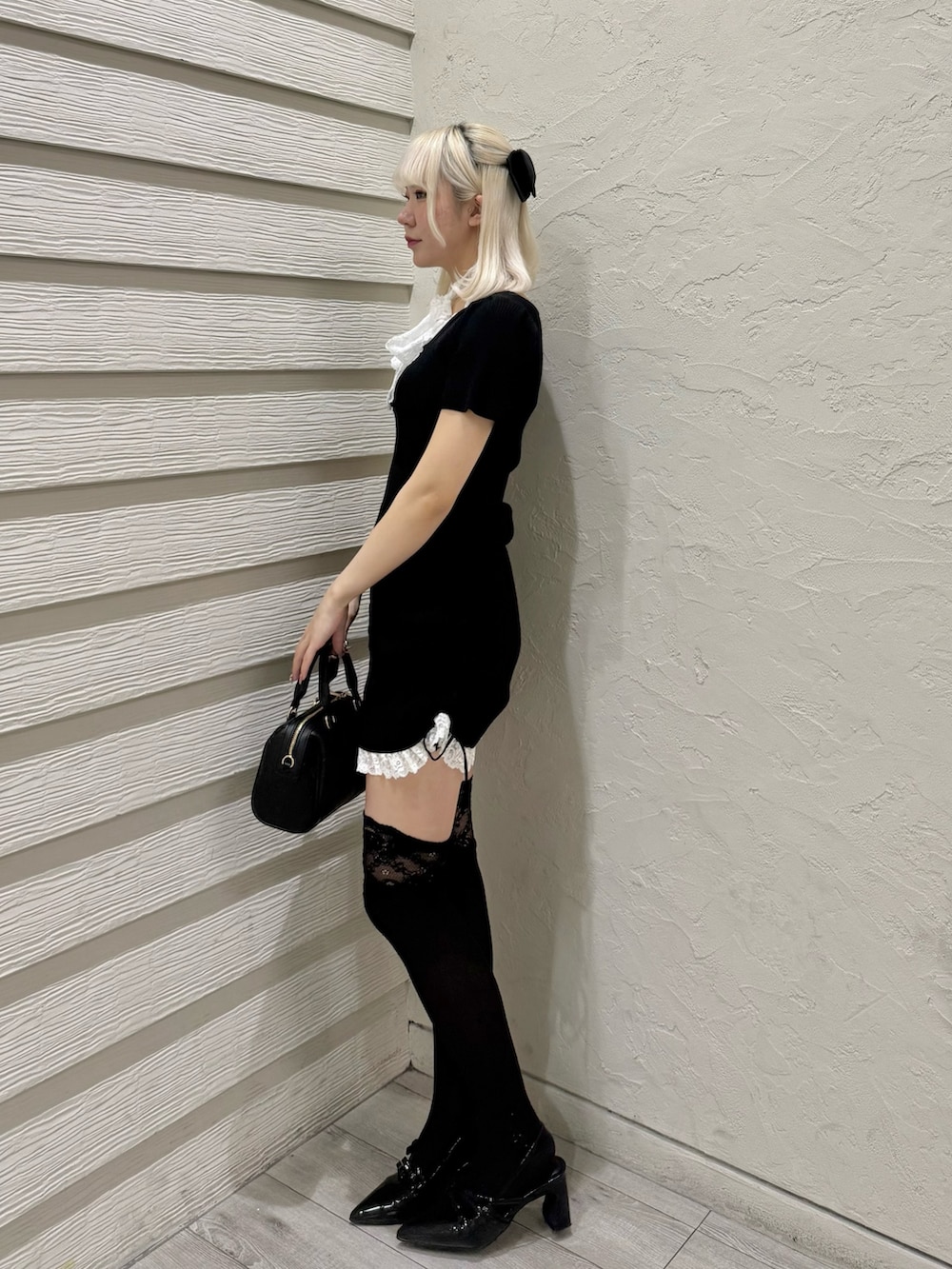 ブラック系のワンピース、ブラック系のショルダーバッグ、ブラック系のパンプスを着用したレディースの夏コーディネートの2枚目の写真