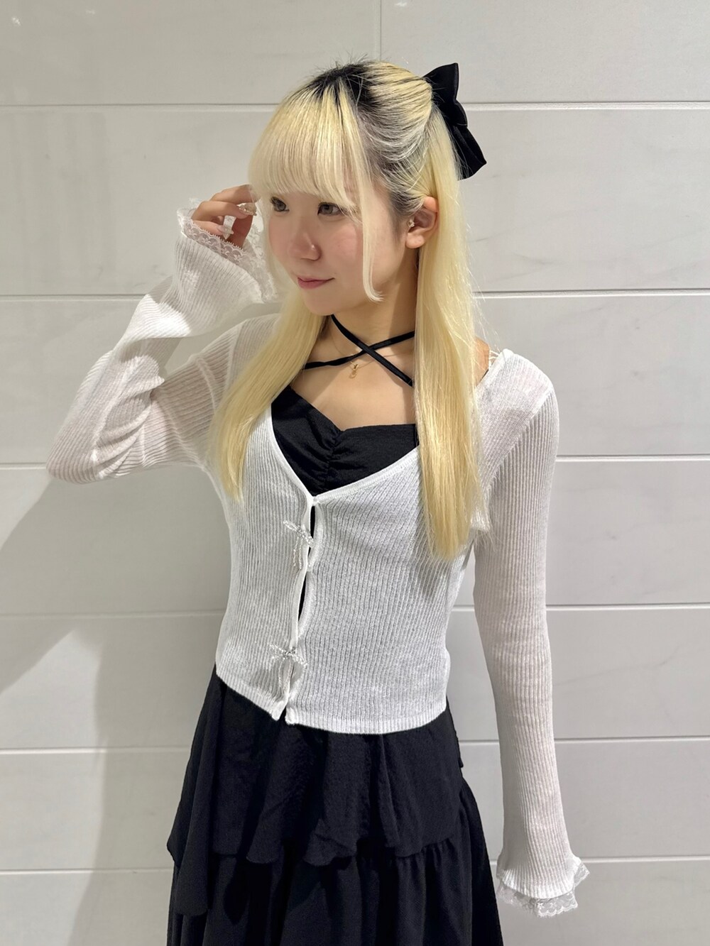 ホワイト系のカーディガン/ボレロ、ブラック系のワンピース、ホワイト系のサンダルを着用したレディースの春コーディネートの3枚目の写真