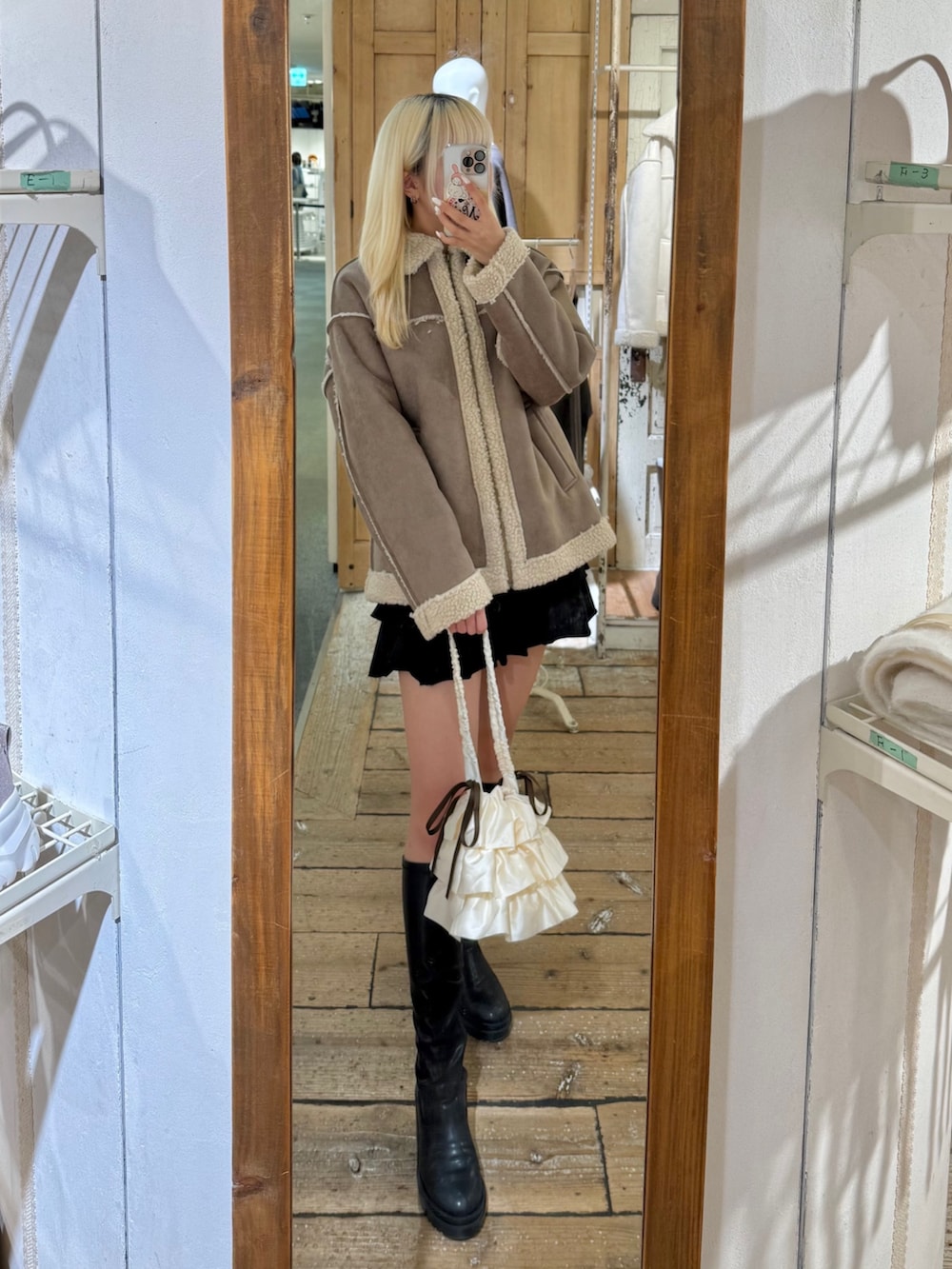 ブラウン系のブルゾン、ブラック系のスカートを着用したレディースの秋コーディネートの2枚目の写真