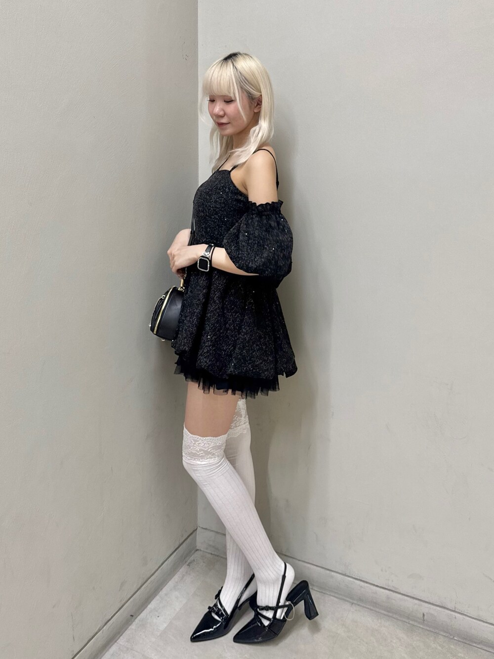 ブラック系のワンピース、ブラック系のショルダーバッグ、ブラック系のパンプスを着用したレディースの春コーディネートの2枚目の写真