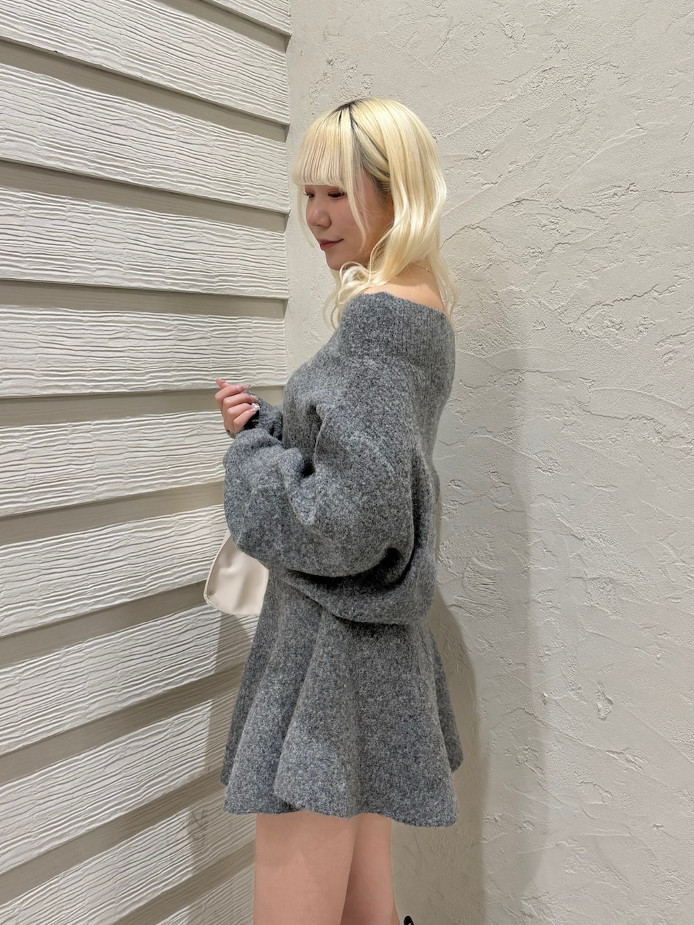 グレー系のセットアップ、ピンク系のトートバッグ、ブラック系のブーツを着用したレディースの冬コーディネートの5枚目の写真