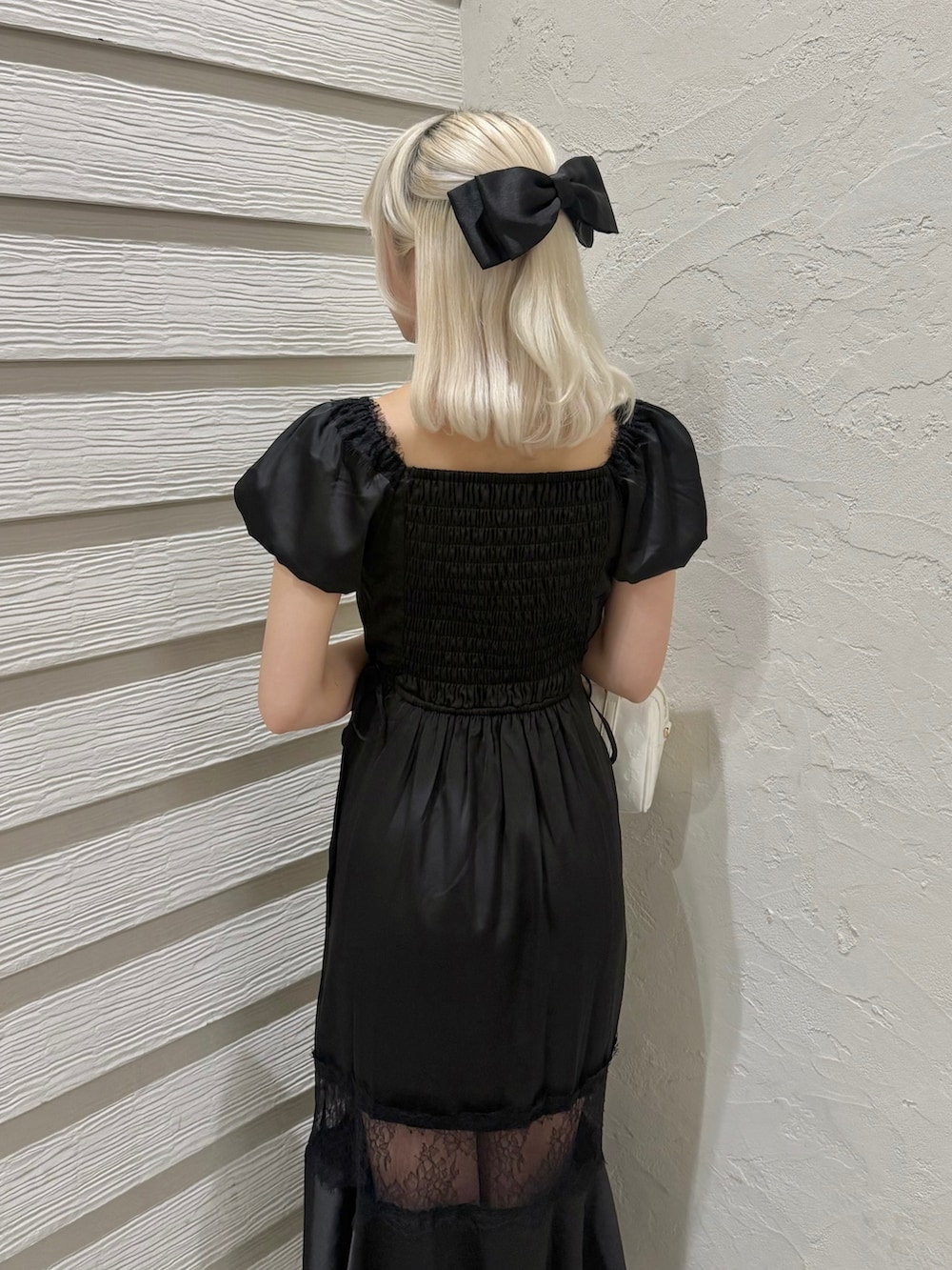 ブラック系のワンピース、ホワイト系のショルダーバッグ、その他のサンダルを着用したレディースの夏コーディネートの6枚目の写真