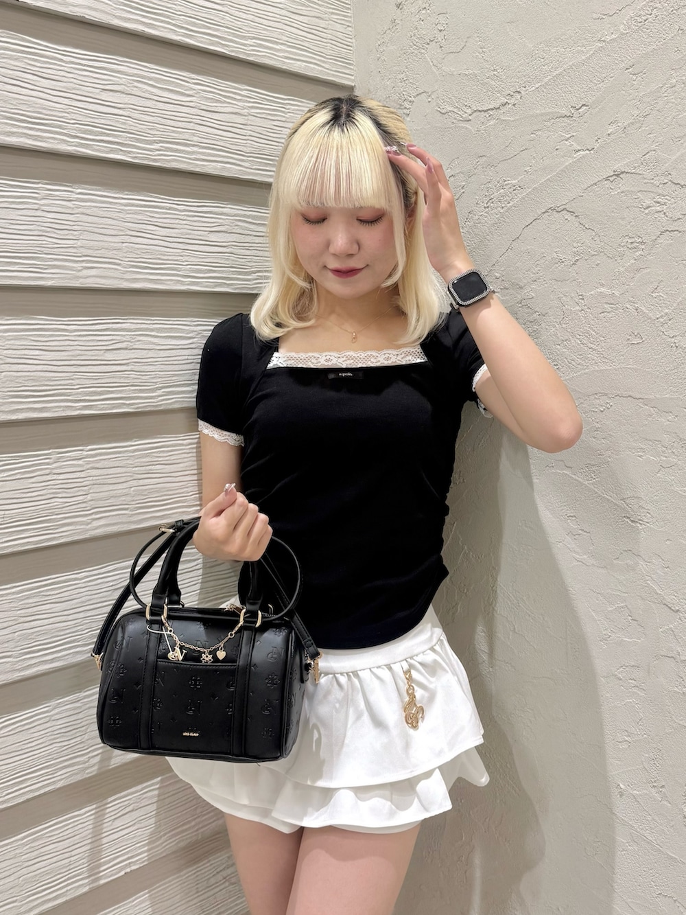 ブラック系のTシャツ/カットソー、ホワイト系のスカート、ブラック系のショルダーバッグを着用したレディースの夏コーディネートの4枚目の写真