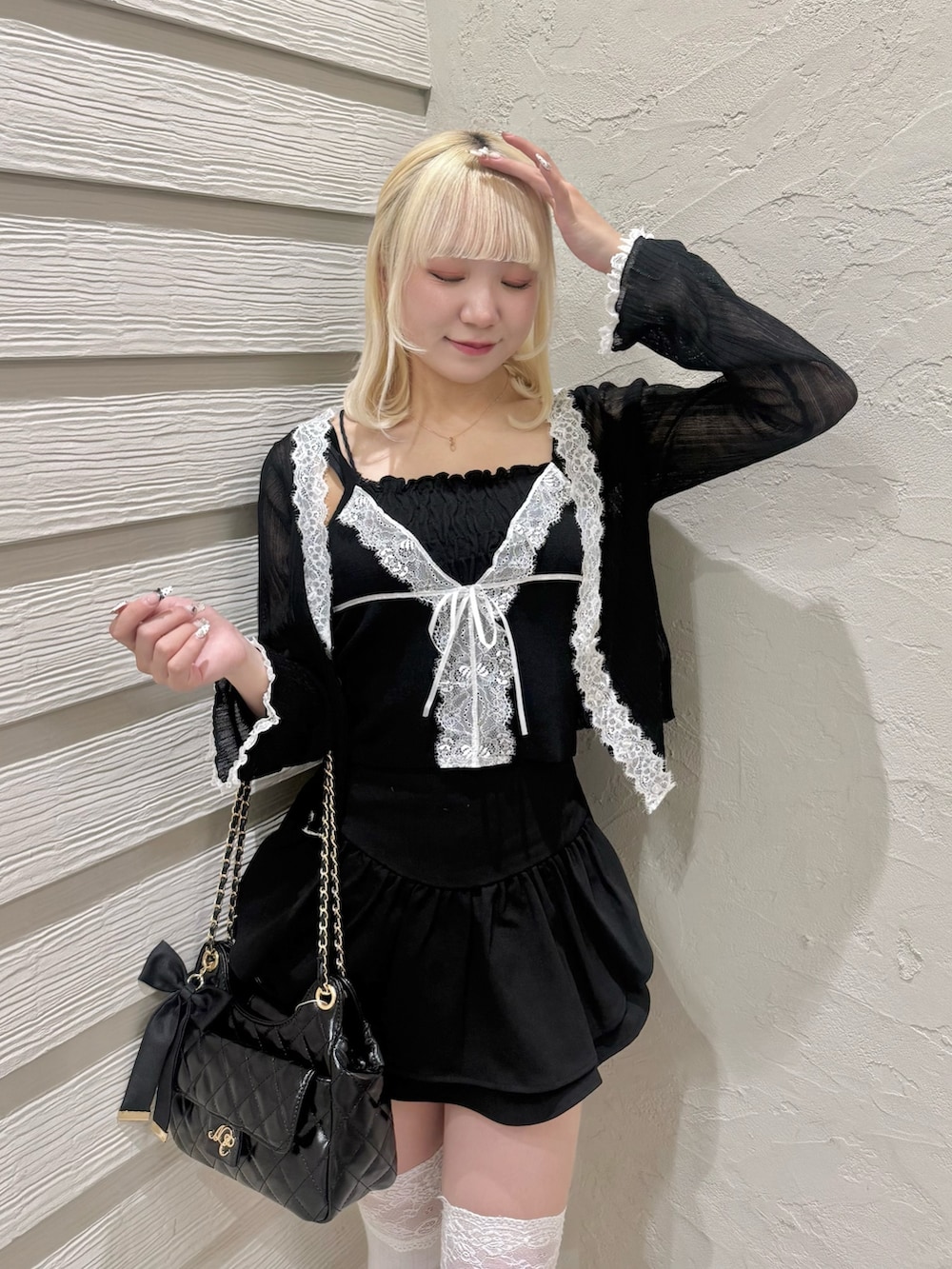 ブラック系のカーディガン/ボレロ、ブラック系のニット/セーター、ブラック系のショルダーバッグを着用したレディースの春コーディネートの4枚目の写真