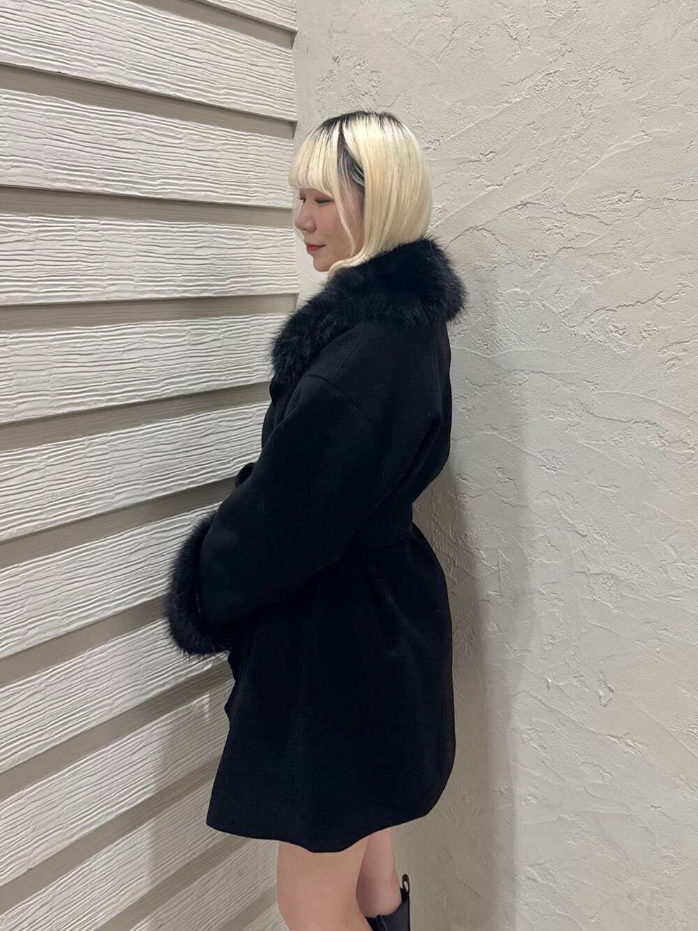 ホワイト系のニット/セーター、ブラック系のステンカラーコート、ホワイト系のショルダーバッグを着用したレディースの冬コーディネートの5枚目の写真