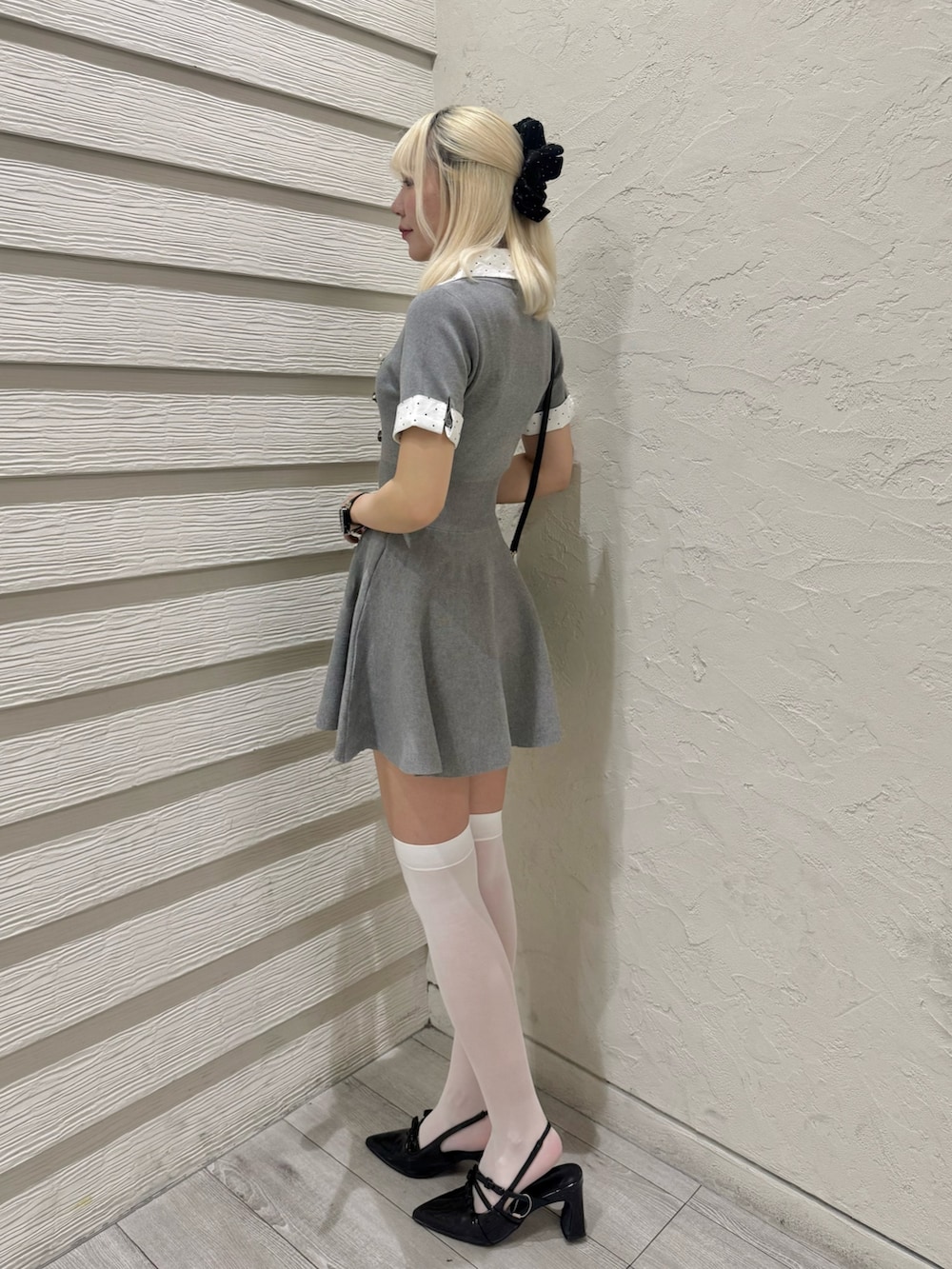ブラック系のパンプス、ブラック系のショルダーバッグ、グレー系のワンピースを着用したレディースの夏コーディネートの2枚目の写真