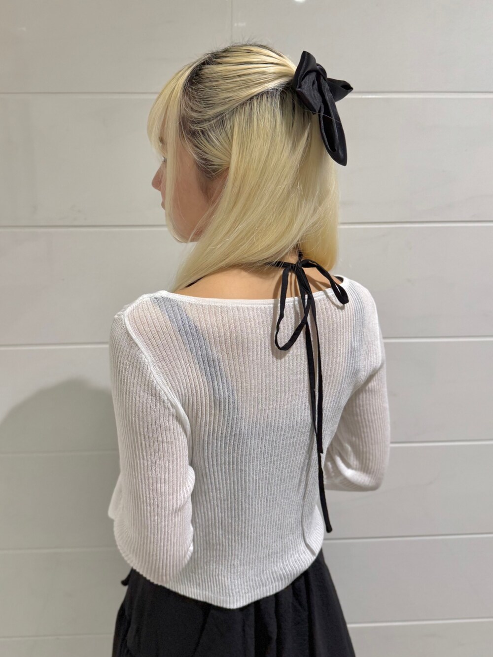 ホワイト系のカーディガン/ボレロ、ブラック系のワンピース、ホワイト系のサンダルを着用したレディースの春コーディネートの4枚目の写真