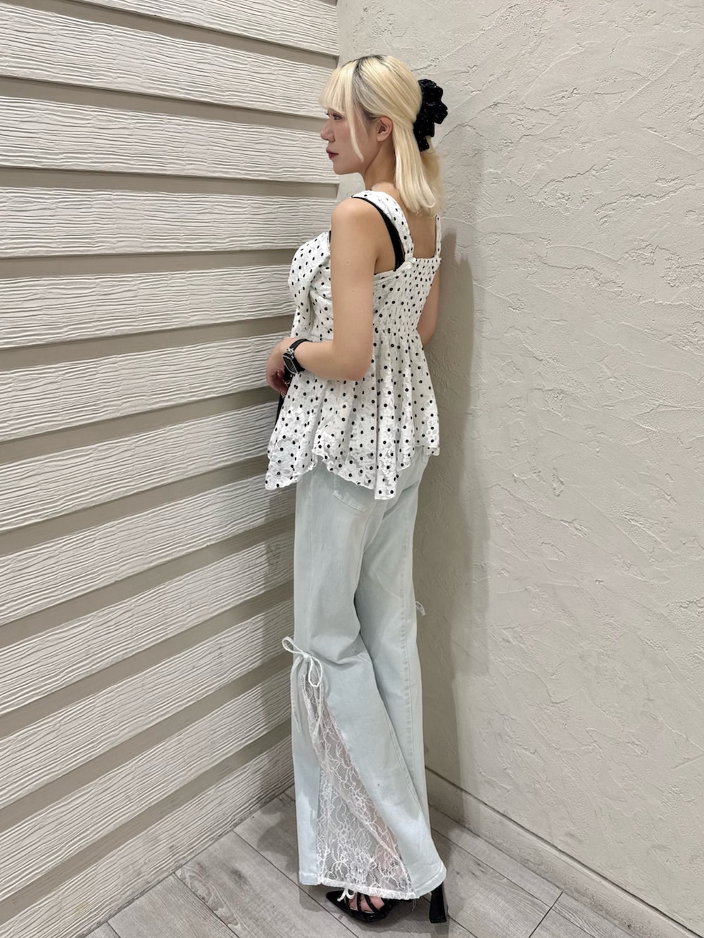 ブラック系のショルダーバッグ、ブルー系のデニムパンツ、ブラック系のサンダルを着用したレディースの夏コーディネートの8枚目の写真