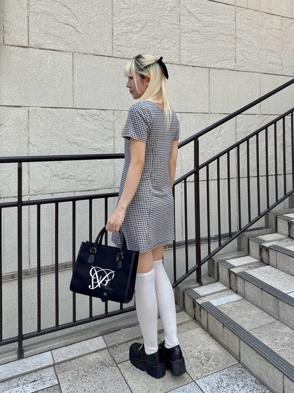 ブラック系のトートバッグ、その他のワンピースを着用したレディースの春コーディネートの2枚目の写真