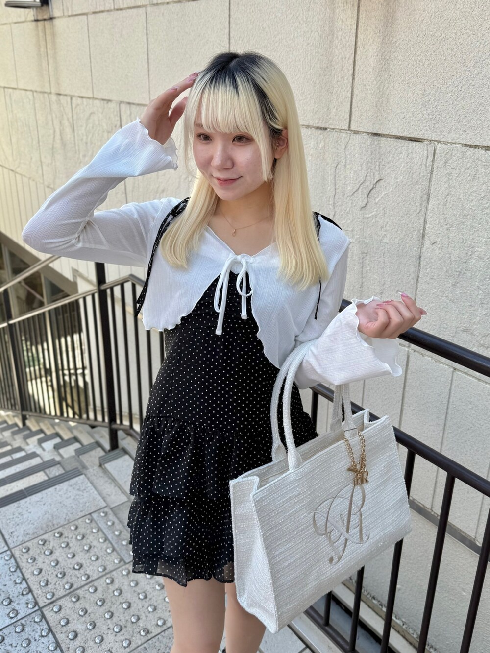 ブラック系のワンピース、ホワイト系のトートバッグを着用したレディースの夏コーディネートの4枚目の写真