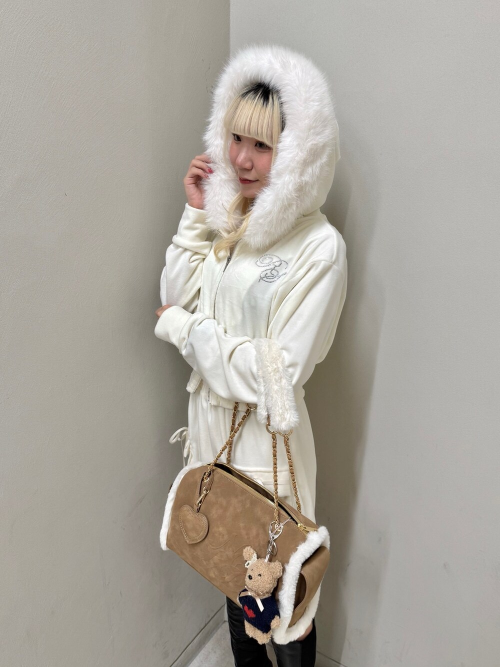 ベージュ系のパーカー、ベージュ系のスカート、イエロー系のボストンバッグを着用したレディースの冬コーディネートの6枚目の写真