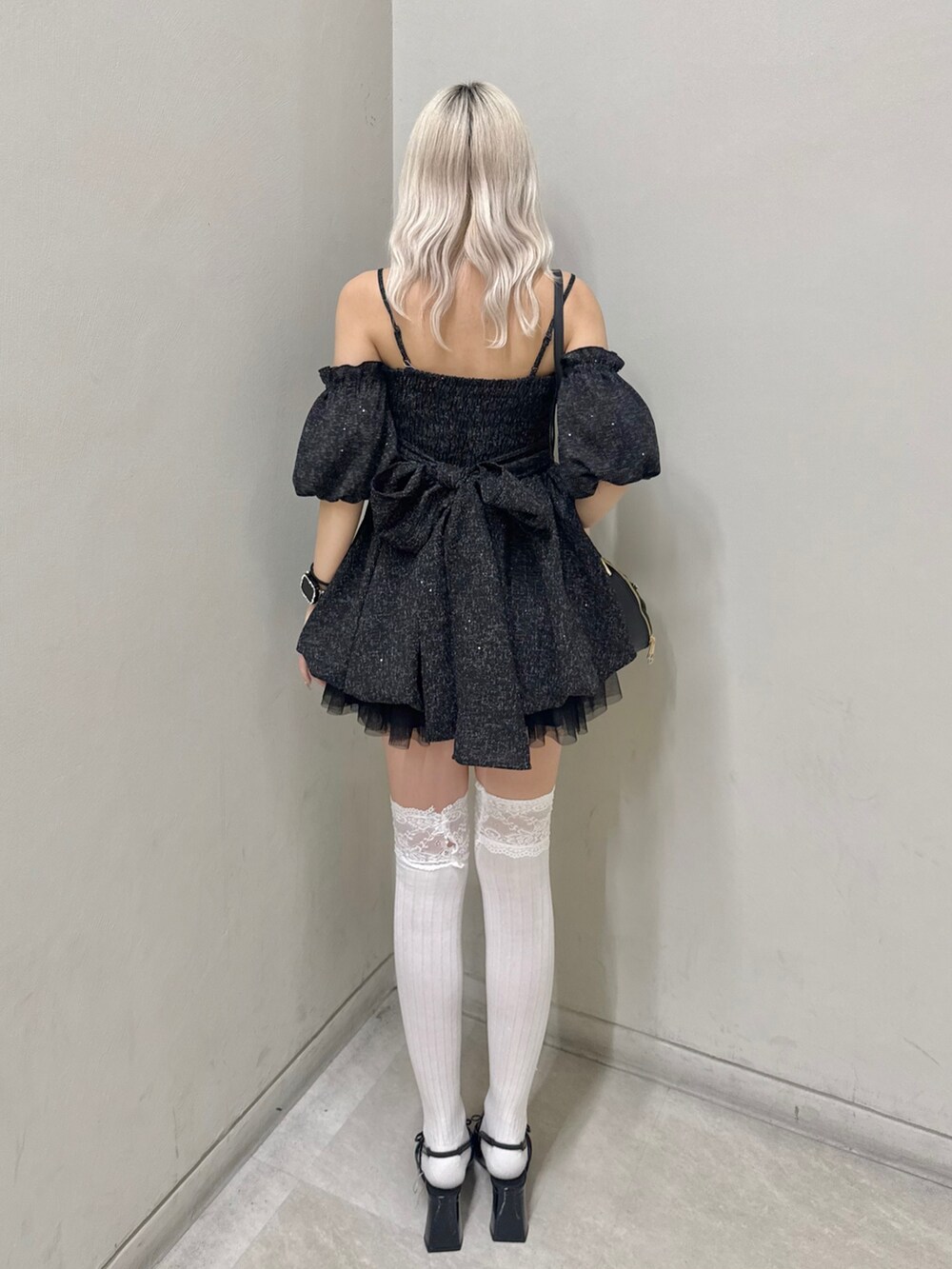 ブラック系のワンピース、ブラック系のショルダーバッグ、ブラック系のパンプスを着用したレディースの春コーディネートの3枚目の写真