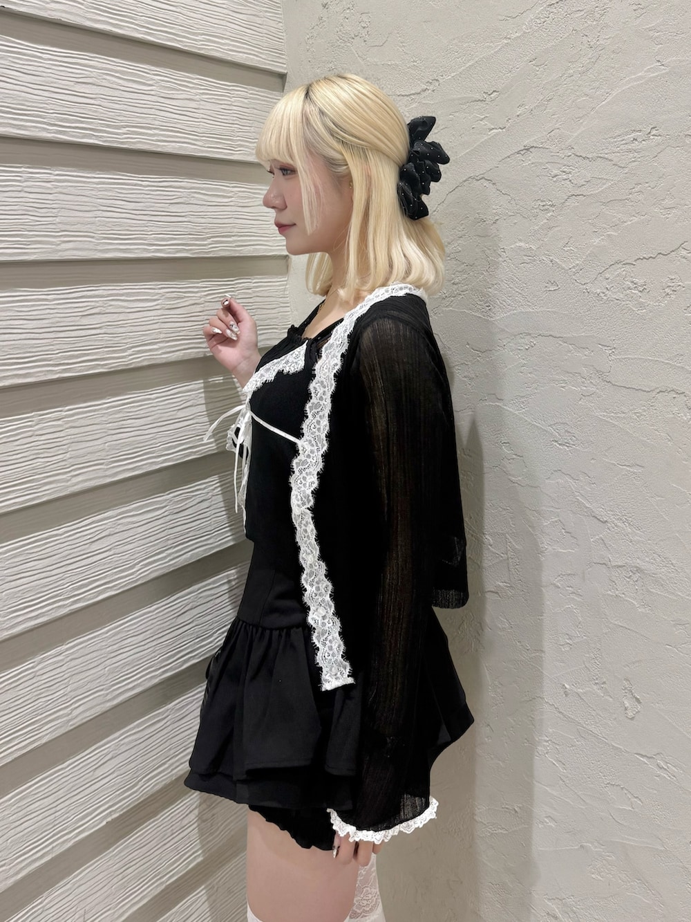 ブラック系のカーディガン/ボレロ、ブラック系のニット/セーター、ブラック系のショルダーバッグを着用したレディースの春コーディネートの5枚目の写真