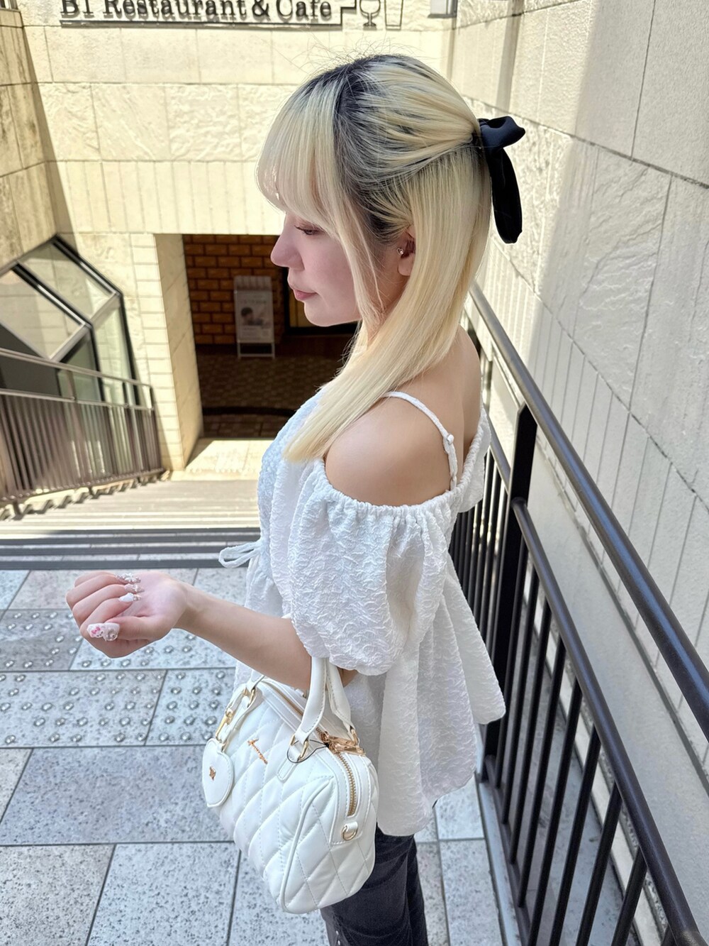 ホワイト系のシャツ/ブラウス、ブラック系のデニムパンツ、ホワイト系のボストンバッグを着用したレディースの夏コーディネートの4枚目の写真