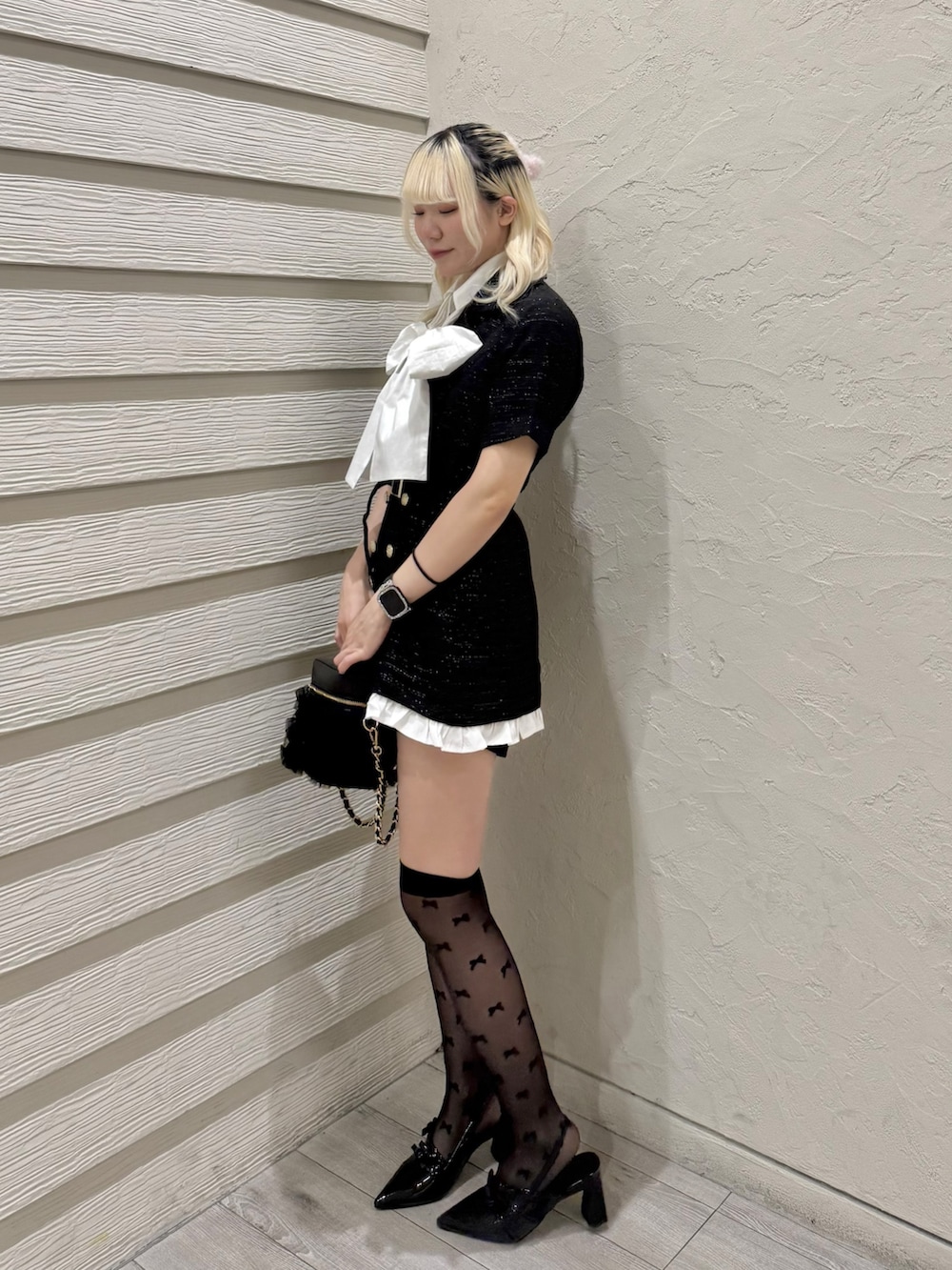 ブラック系のワンピース、ホワイト系のシャツ/ブラウス、ブラック系のパンプスを着用したレディースの春コーディネートの2枚目の写真
