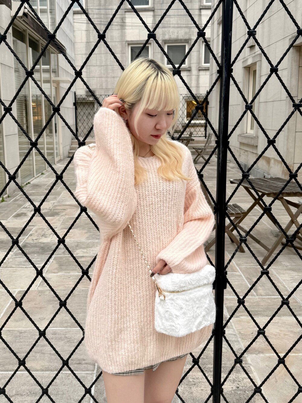 ホワイト系のショルダーバッグ、ピンク系のワンピース、その他のスカートを着用したレディースの秋コーディネートの3枚目の写真