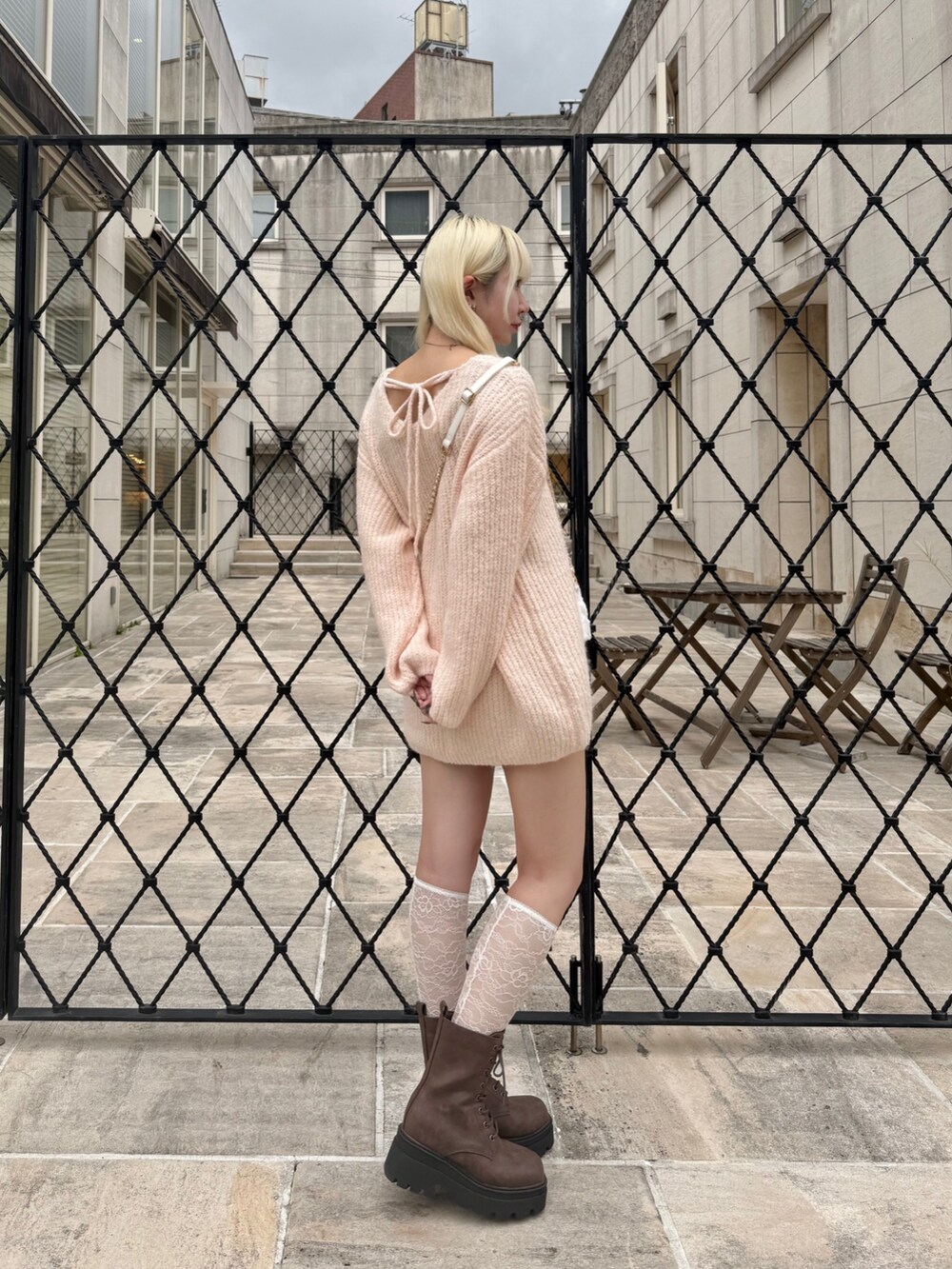 ホワイト系のショルダーバッグ、ピンク系のワンピース、その他のスカートを着用したレディースの秋コーディネートの2枚目の写真