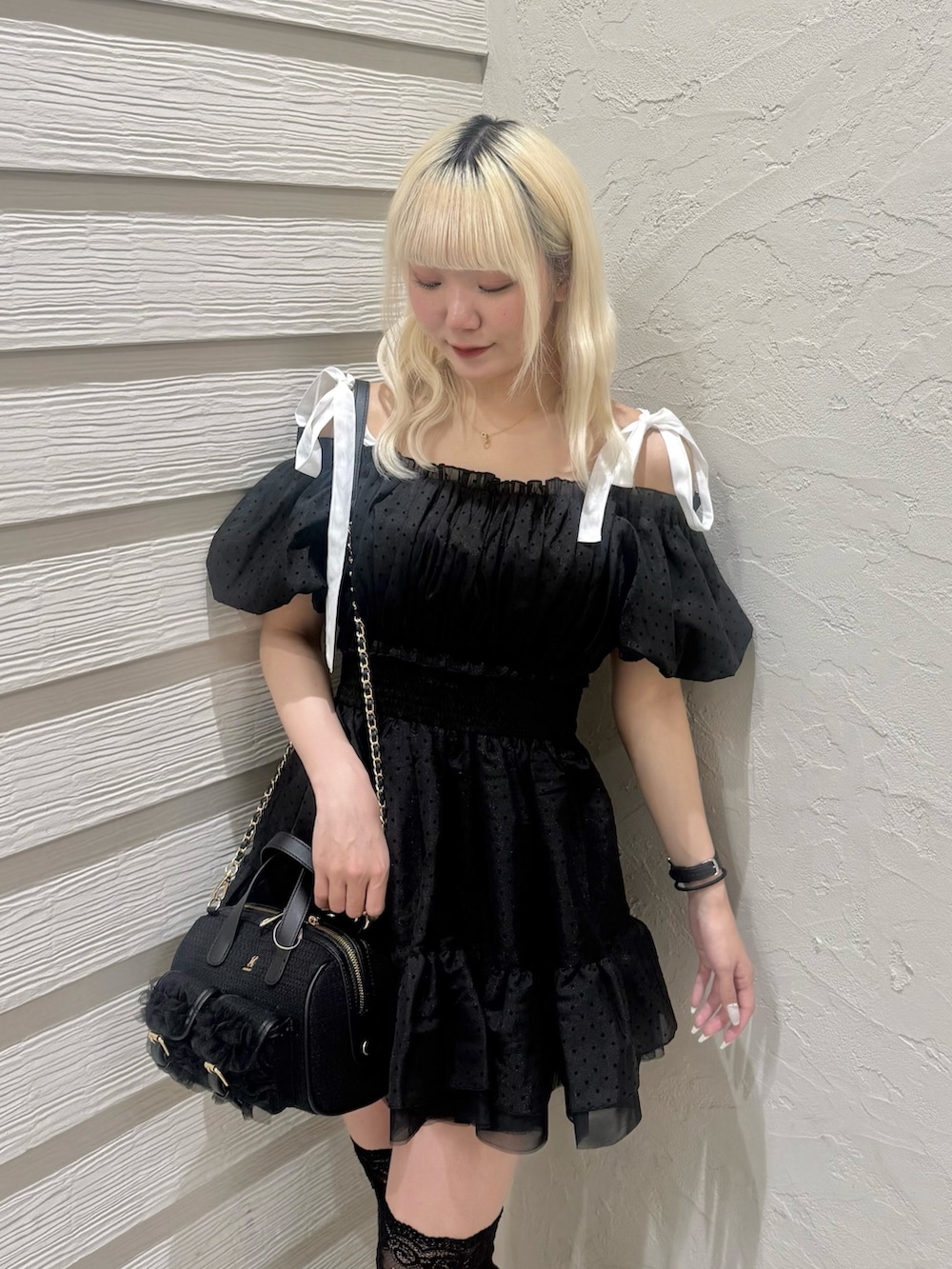 ブラック系のショルダーバッグ、ブラック系のパンプス、ブラック系のワンピースを着用したレディースの春コーディネートの4枚目の写真
