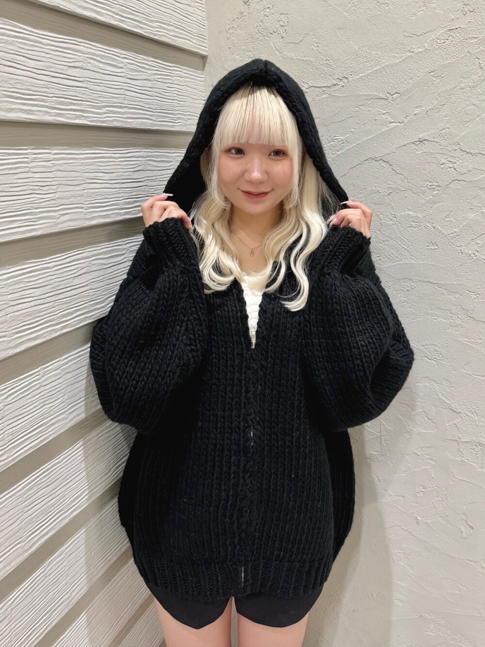 ブラック系のニット/セーター、ホワイト系のキャミソール、ブラック系のその他パンツを着用したレディースの秋コーディネートの4枚目の写真