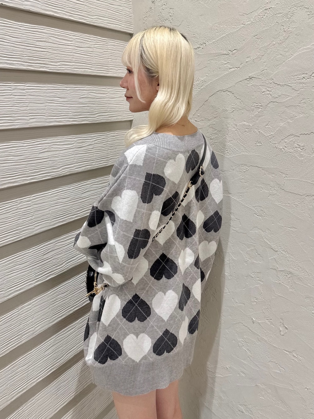 ブラック系のショルダーバッグ、グレー系のワンピース、ブラック系のブーツを着用したレディースの冬コーディネートの5枚目の写真