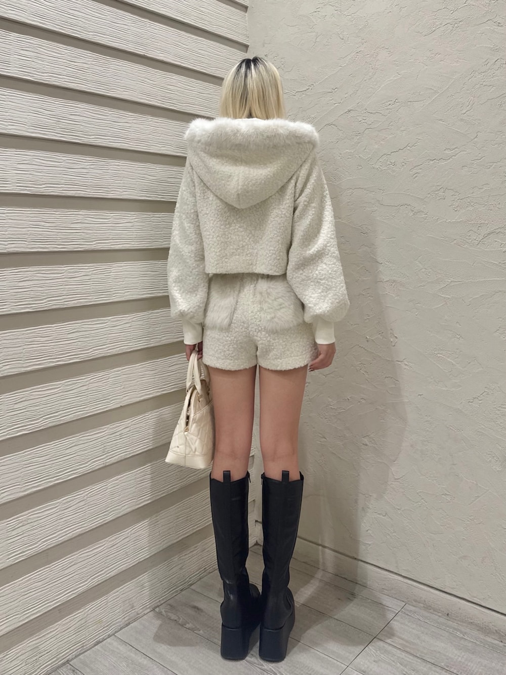 ホワイト系のその他パンツ、ホワイト系のその他アウター、ホワイト系のハンドバッグを着用したレディースの冬コーディネートの3枚目の写真