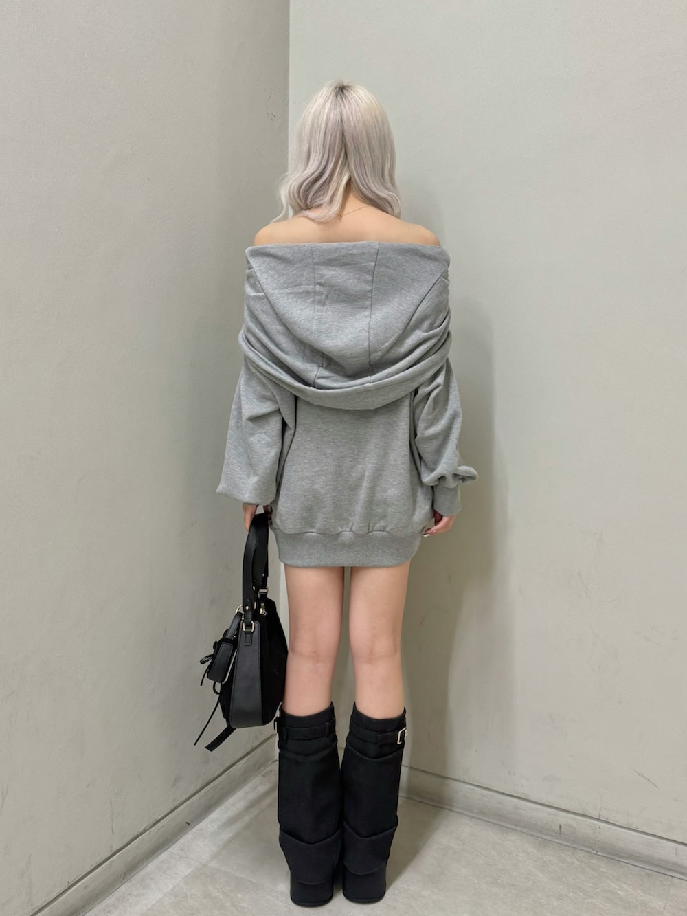 グレー系のパーカー、ブラック系のショルダーバッグ、ブラック系のスニーカーを着用したレディースの春コーディネートの3枚目の写真