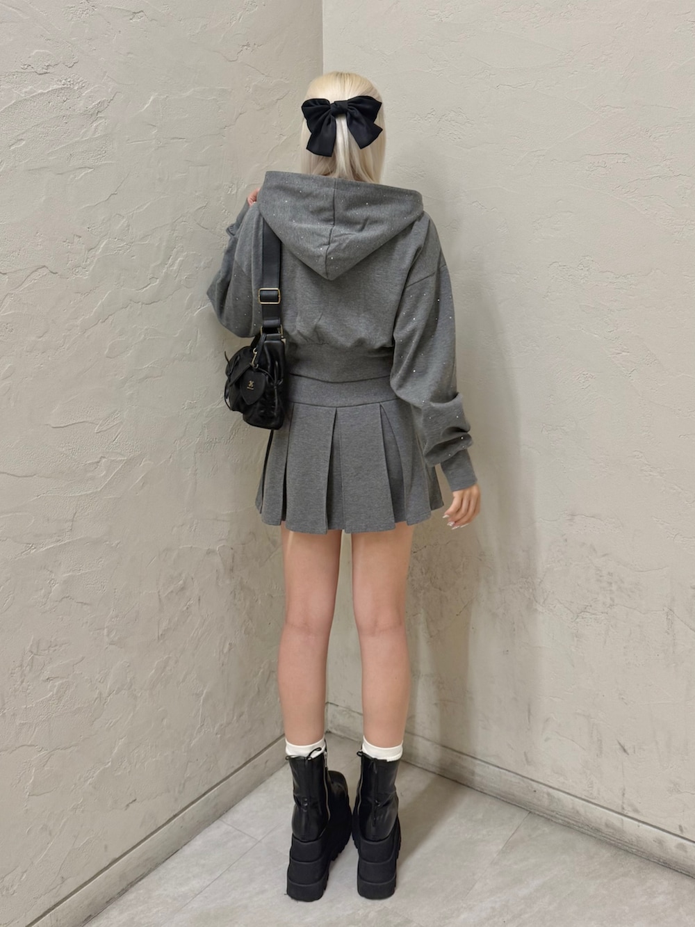 ブラック系のショルダーバッグ、グレー系のパーカー、グレー系のスカートを着用したレディースの秋コーディネートの4枚目の写真