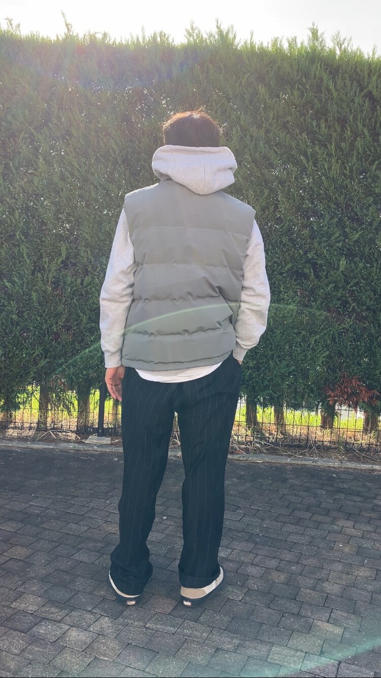 グレー系のダウンベストを着用したメンズの秋コーディネートの3枚目の写真