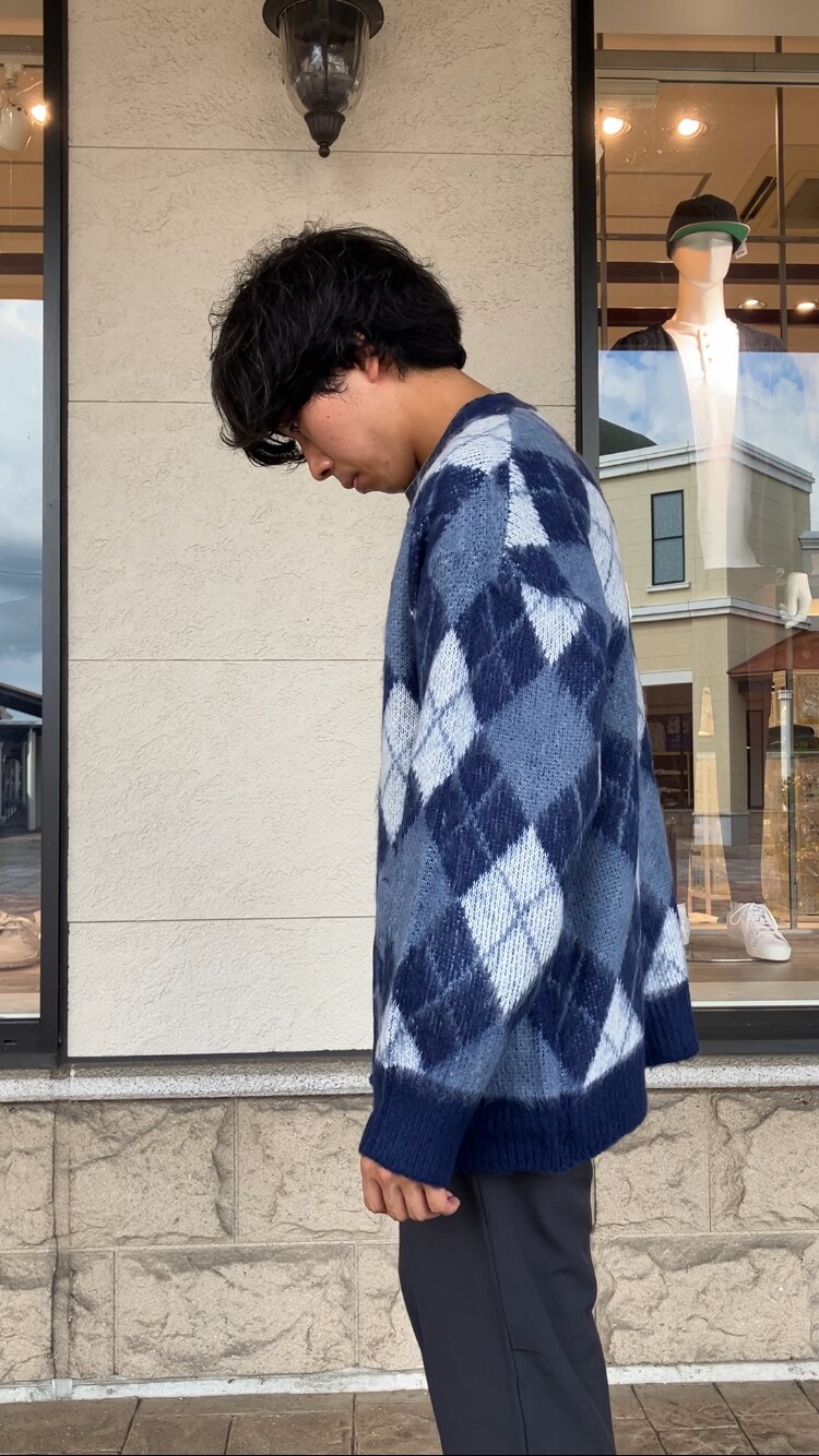 グレー系のスラックス、ブルー系のカーディガン/ボレロを着用したメンズの秋コーディネートの2枚目の写真