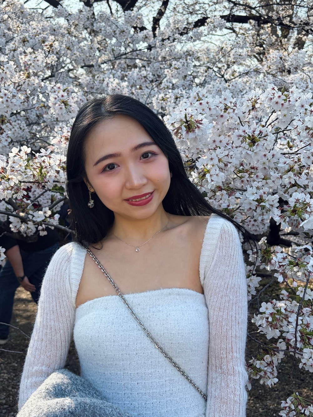 グレー系のジャケット/アウター、ホワイト系のニット/セーター、ブルー系のデニムパンツを着用したレディースの春コーディネートの4枚目の写真