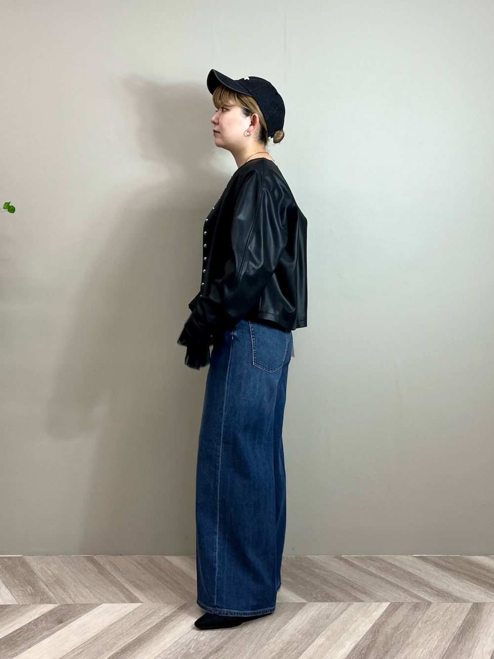 ブラック系のその他アウター、ブラック系のTシャツ/カットソー、ブルー系のデニムパンツを着用したレディースの秋コーディネートの2枚目の写真