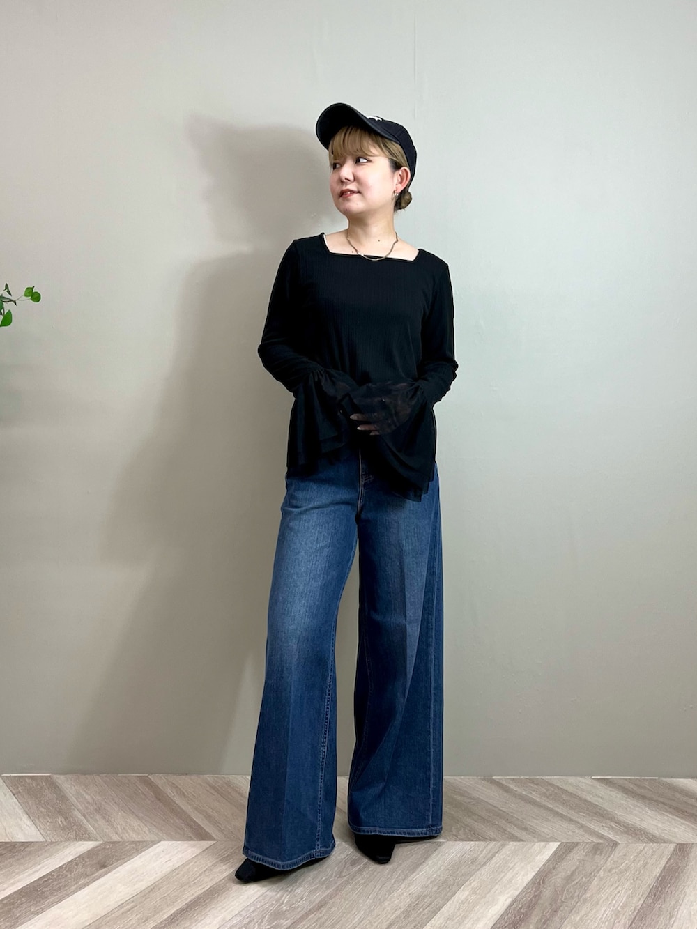 ブラック系のその他アウター、ブラック系のTシャツ/カットソー、ブルー系のデニムパンツを着用したレディースの秋コーディネートの6枚目の写真