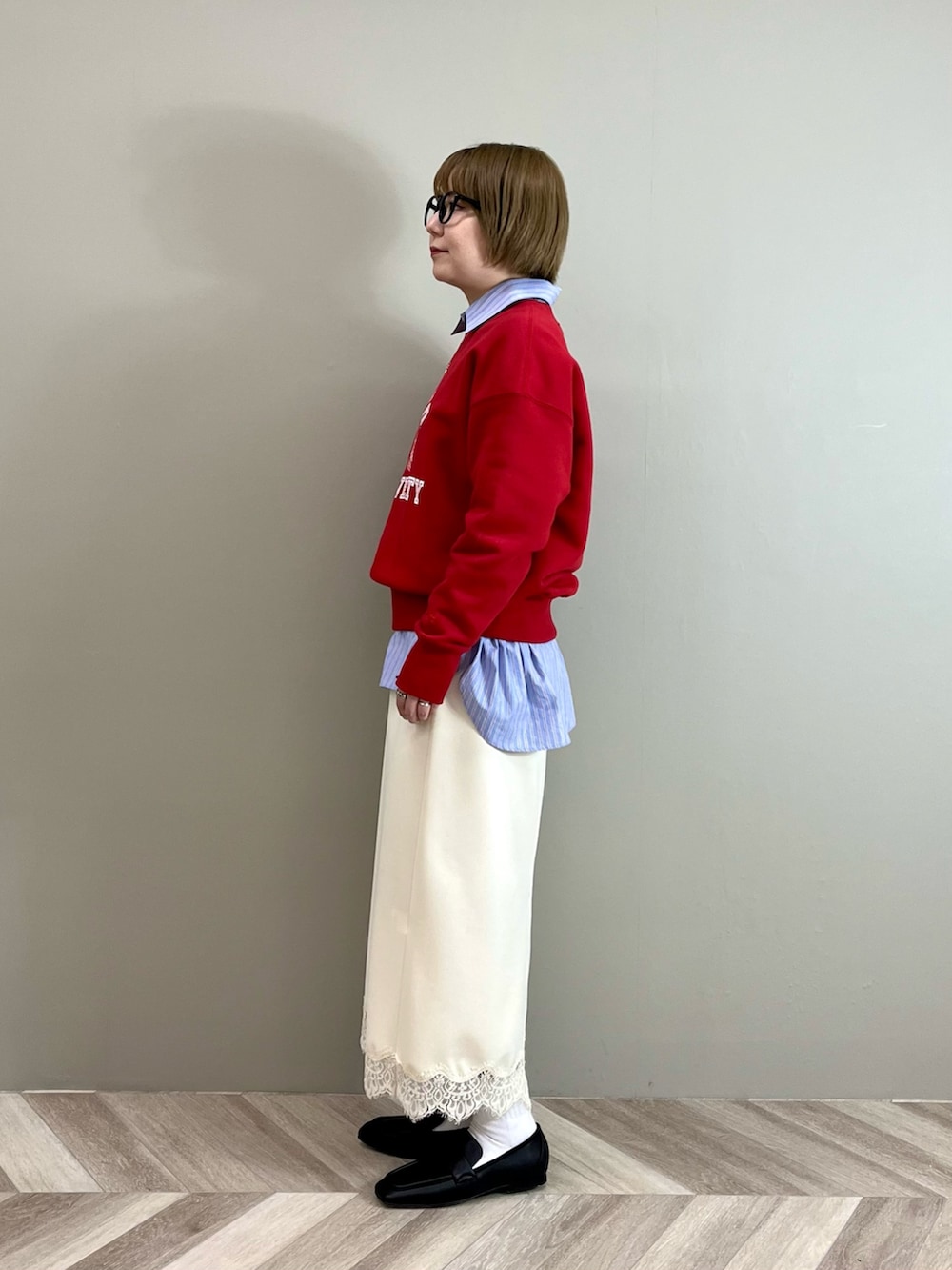 ブルー系のシャツ/ブラウス、レッド系のスウェット、ホワイト系のスカートを着用したレディースの冬コーディネートの2枚目の写真