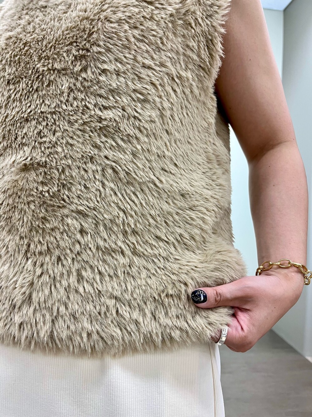 ホワイト系のスカート、ベージュ系のニット/セーター、ブラック系のトートバッグを着用したレディースの夏コーディネートの5枚目の写真