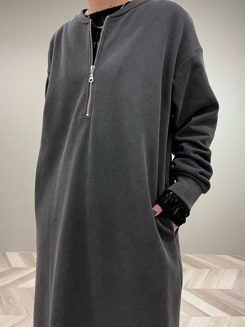 グレー系のワンピース、ブラック系のTシャツ/カットソー、ゴールド系のネックレスを着用したレディースの春コーディネートの4枚目の写真