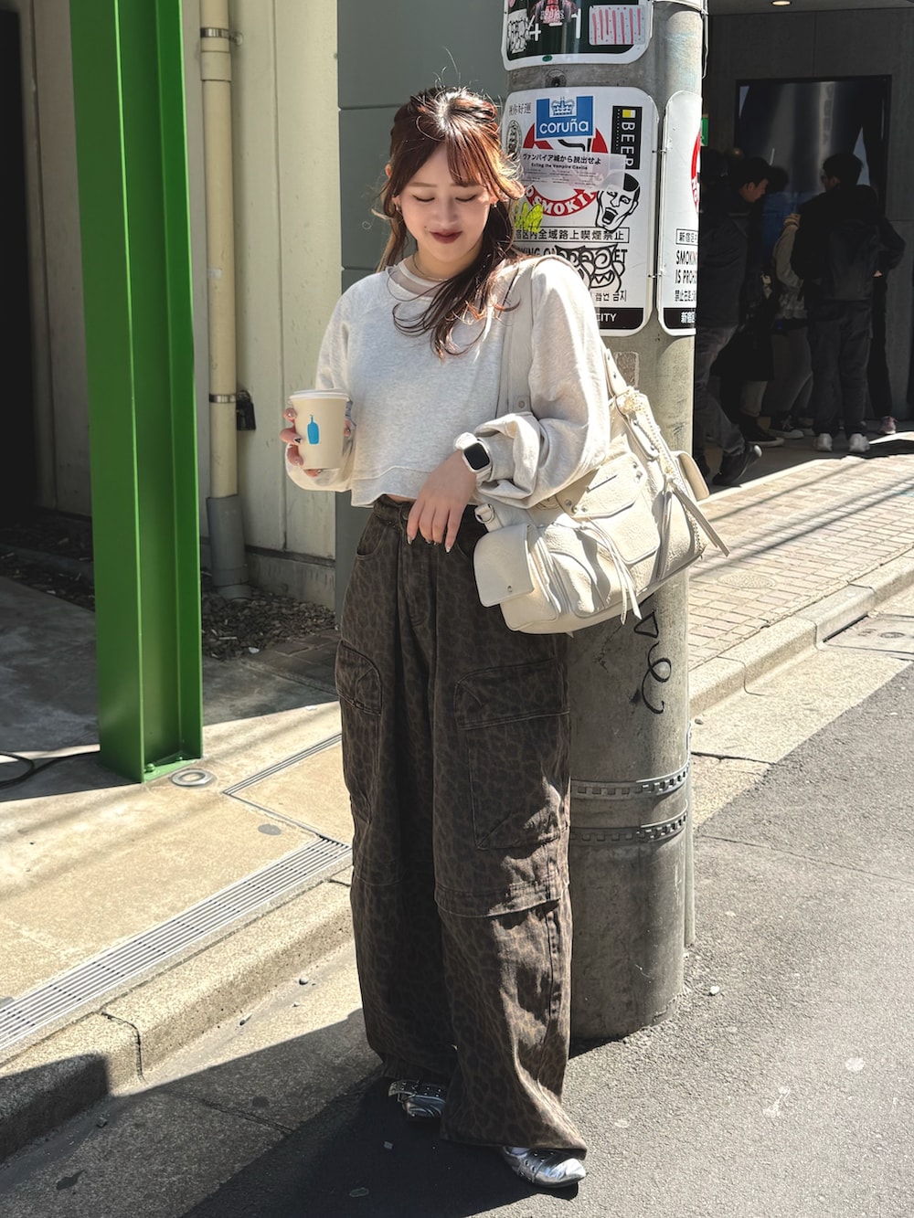 ホワイト系のTシャツ/カットソー、ブラウン系のその他パンツ、ベージュ系のショルダーバッグを着用したレディースの春コーディネートの2枚目の写真