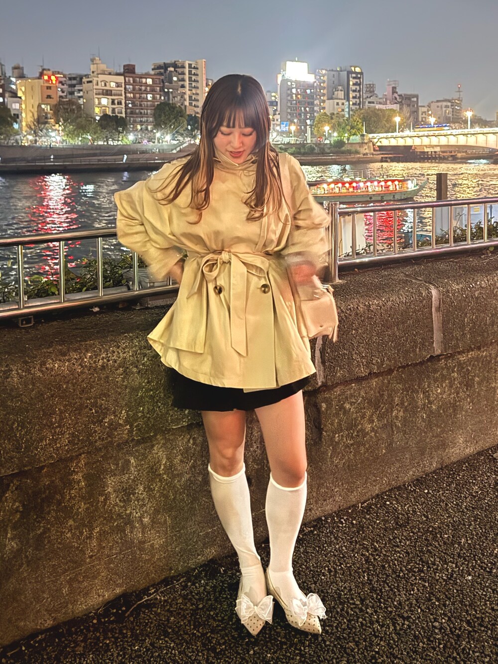 ベージュ系のトレンチコート、ベージュ系のショルダーバッグ、ホワイト系のパンプスを着用したレディースの春コーディネートの2枚目の写真