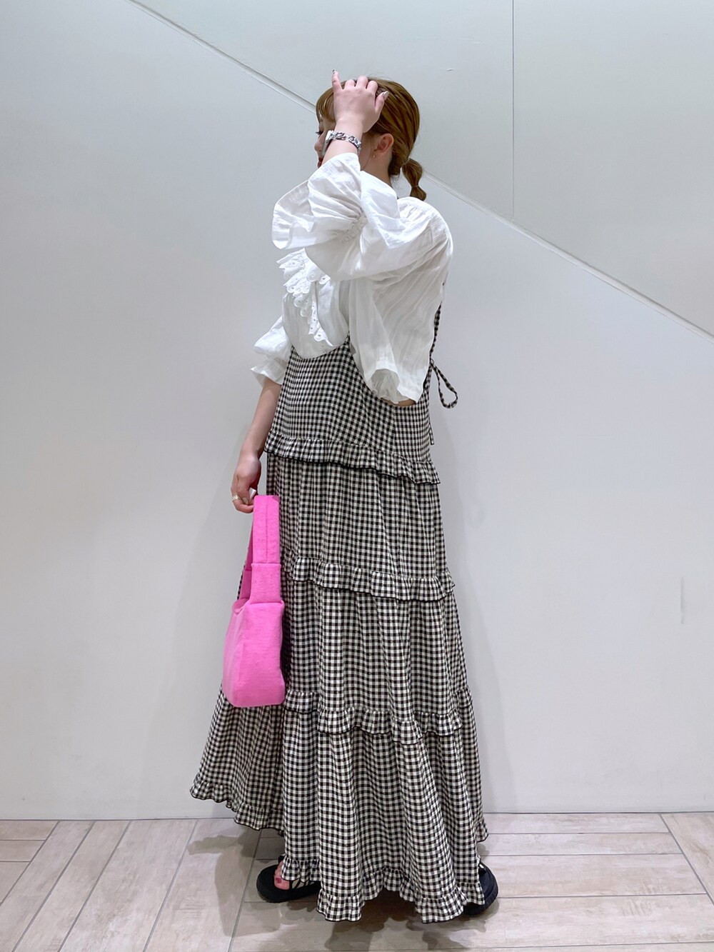 ブラック系のワンピース、ホワイト系のシャツ/ブラウス、ピンク系のハンドバッグを着用したレディースの春コーディネートの2枚目の写真