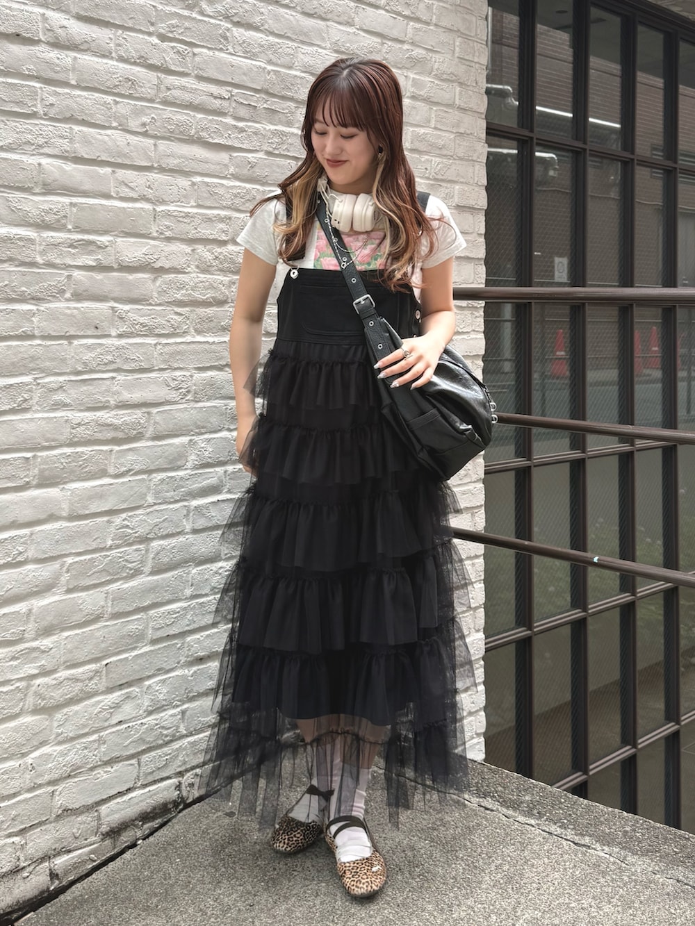 ブラック系のジャンパースカート、ホワイト系のTシャツ/カットソー、ブラック系のトートバッグを着用したレディースの夏コーディネートの2枚目の写真