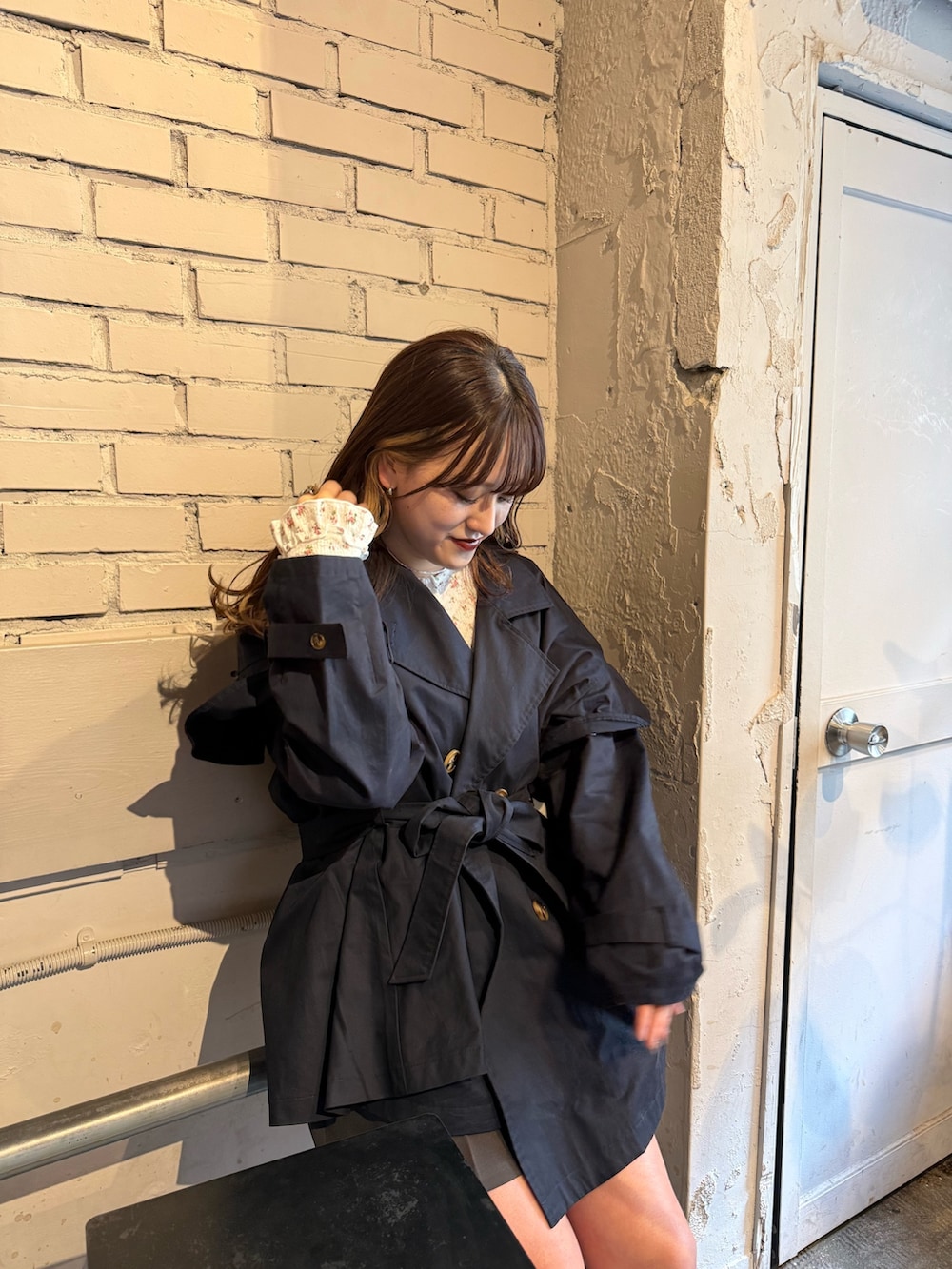 ブルー系のトレンチコート、ホワイト系のTシャツ/カットソー、ブラウン系のブーツを着用したレディースの春コーディネートの3枚目の写真