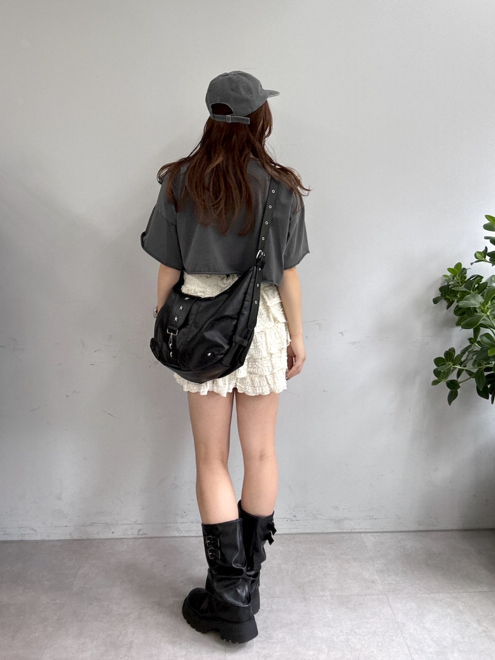 ブラック系のTシャツ/カットソー、ホワイト系のスカート、ブラック系のブーツを着用したレディースの夏コーディネートの2枚目の写真