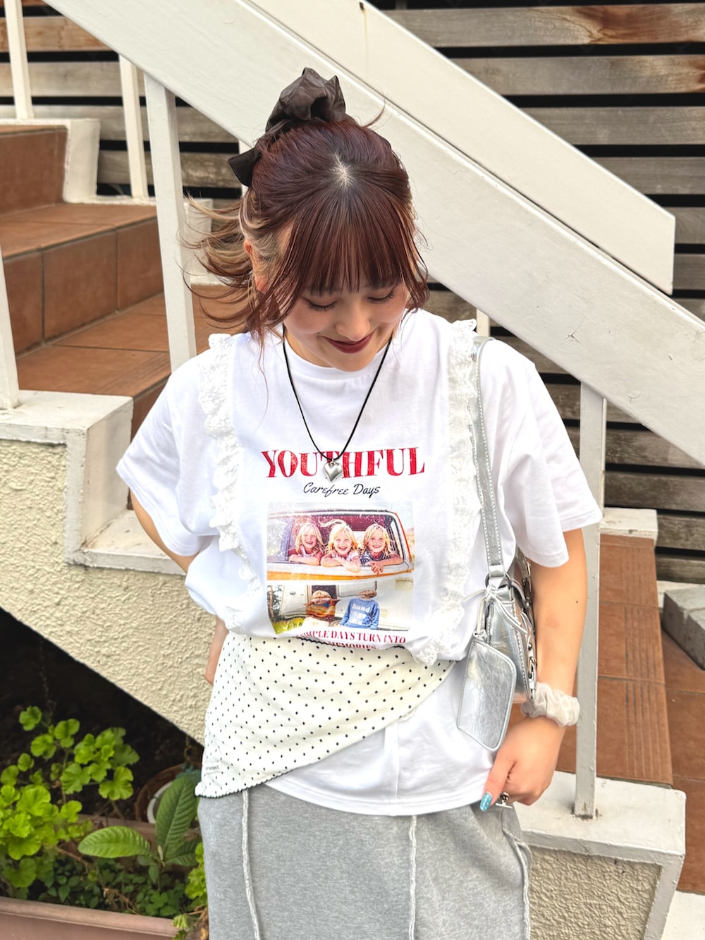 グレー系のスカート、ホワイト系のTシャツ/カットソー、シルバー系のトートバッグを着用したレディースの春コーディネートの3枚目の写真